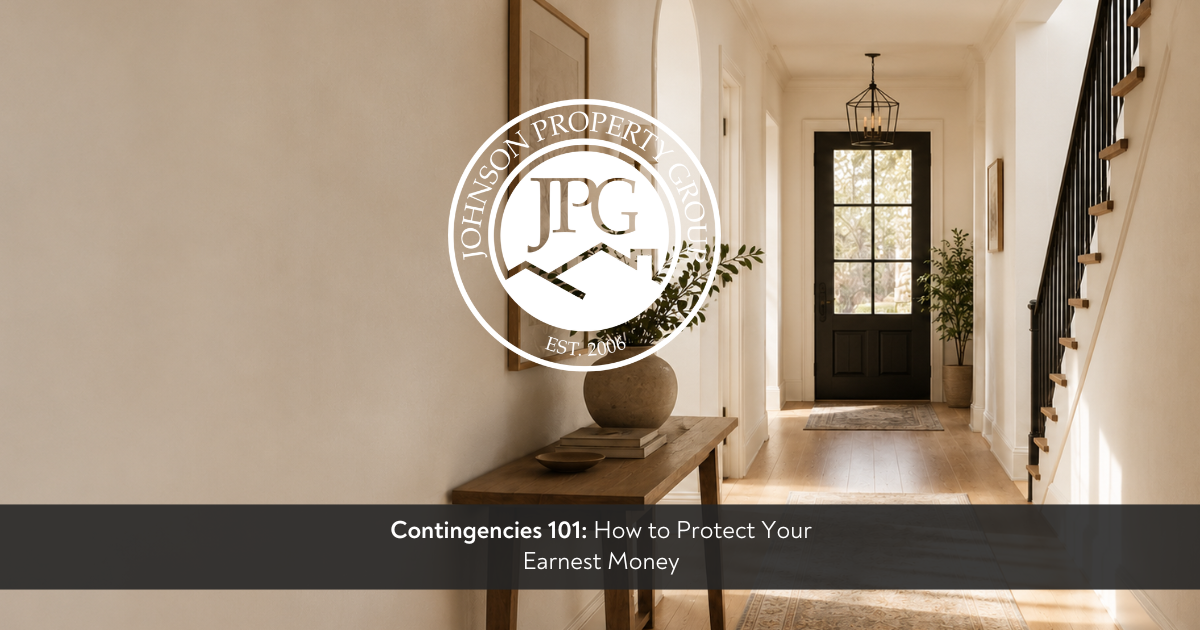 A bright, upscale home hallway with a high-end luxury editorial feel, featuring light beige plaster walls, natural oak hardwood floors, and a dark charcoal front door at the end of the corridor. A minimalist wooden console table holds a textured ceramic vase with greenery. Superimposed in the center is the circular white brand seal for Johnson Property Group EST. 2006, above a clean charcoal banner at the bottom displaying the blog title text: 