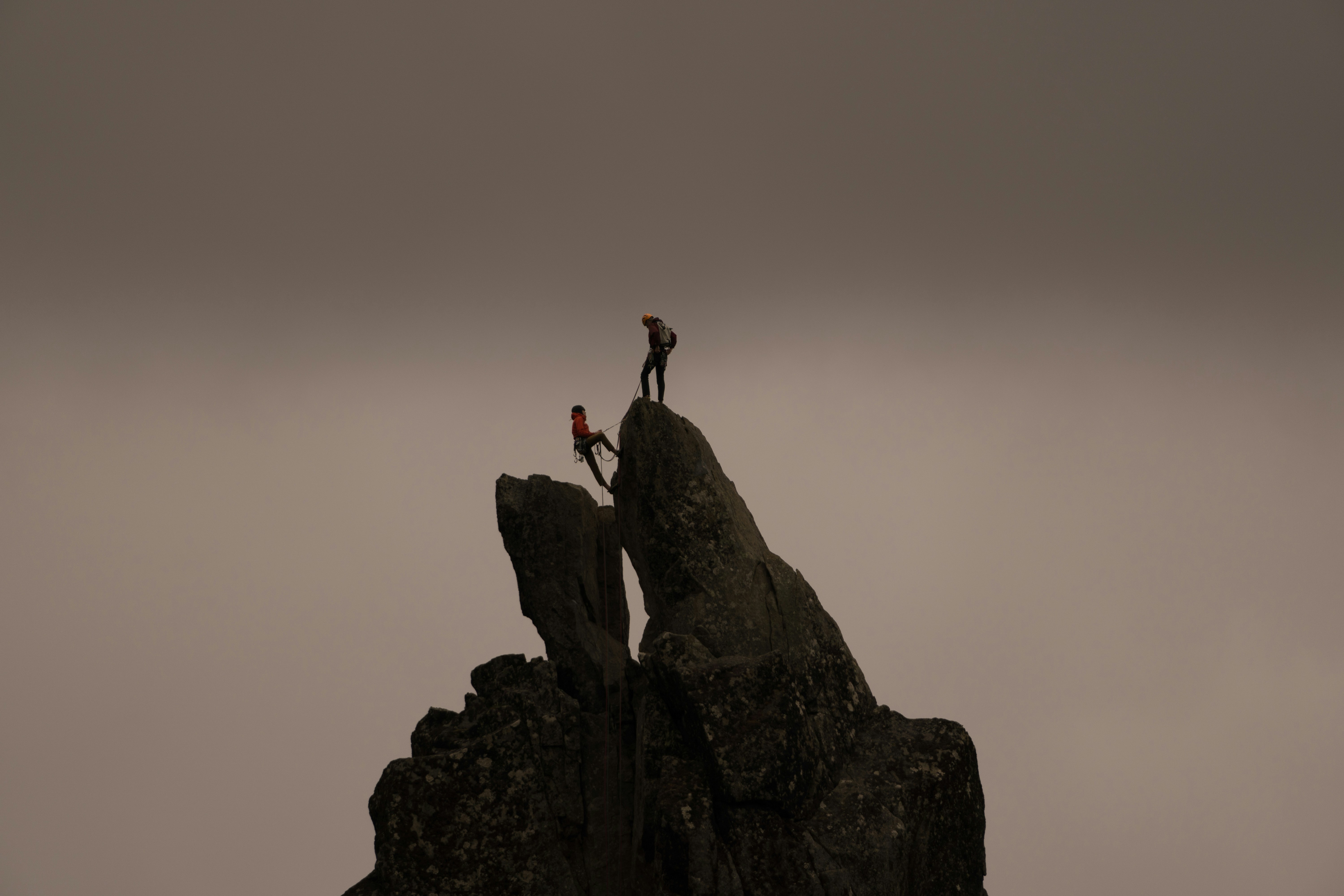 Two people successfully rock climbing