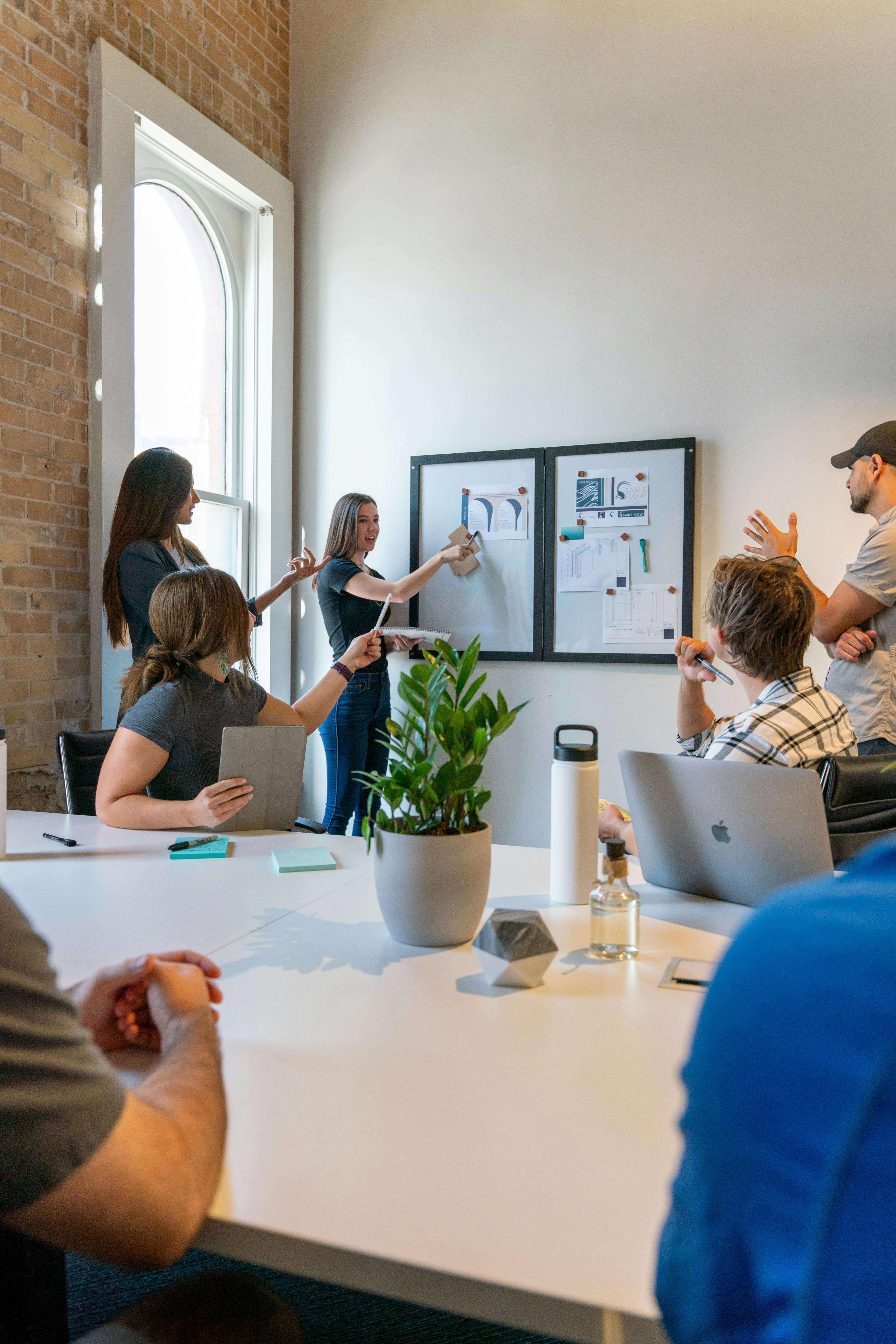 Group of people at the office talkin happily about a poster on the wall