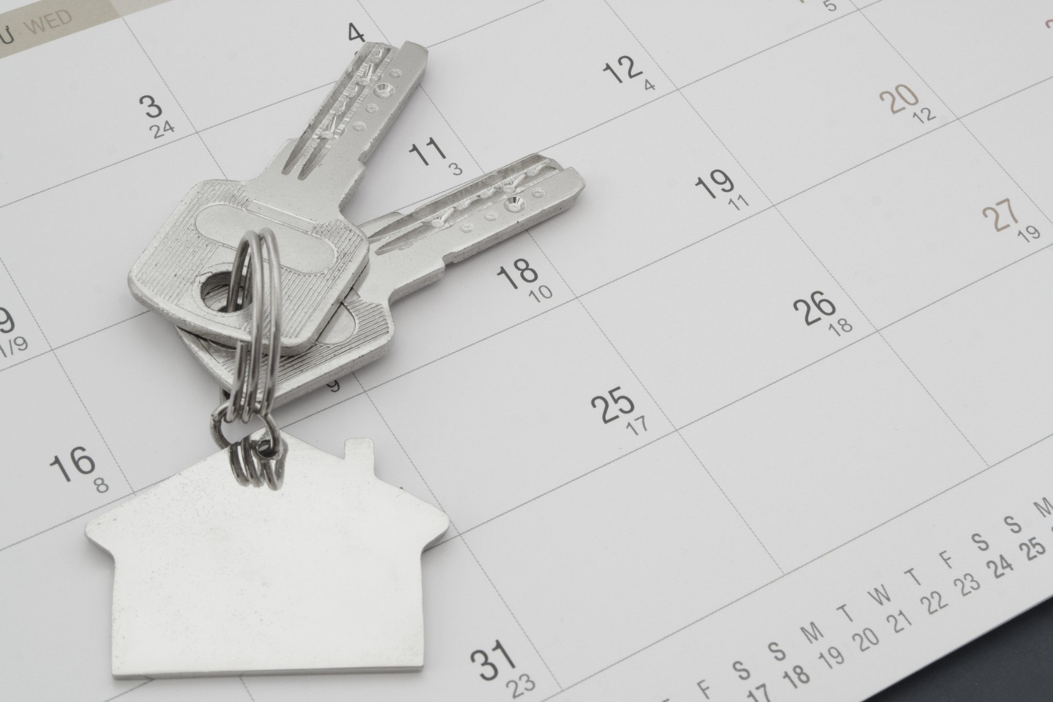 House-shaped keychain and keys on a calendar page, for the timeline to sell an inherited Maryland home
