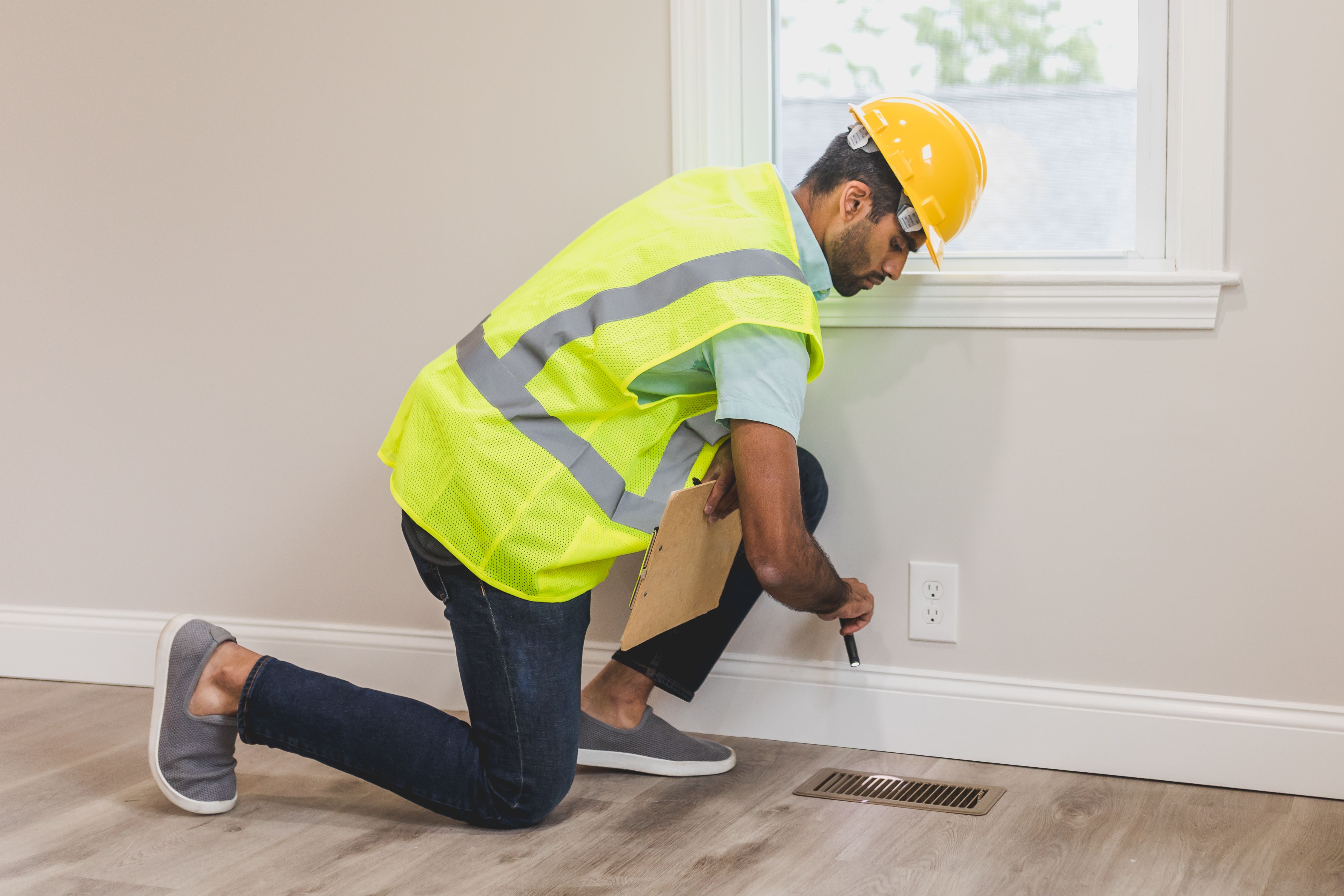 Home inspector checking an electrical outlet in a Baltimore rowhome before selling