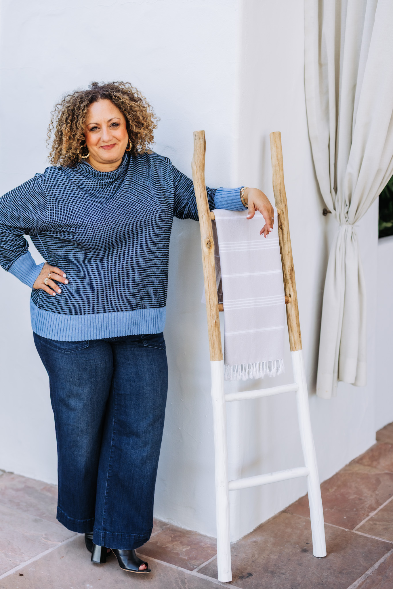 Melina Bradley standing in a blue sweater and blue jeans