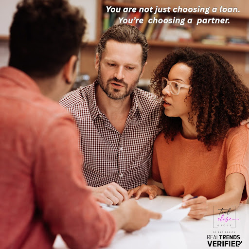 A couple speaks with a lender at a table, reviewing documents together. The image highlights the importance of choosing the right mortgage partner when buying a home in Maryland.