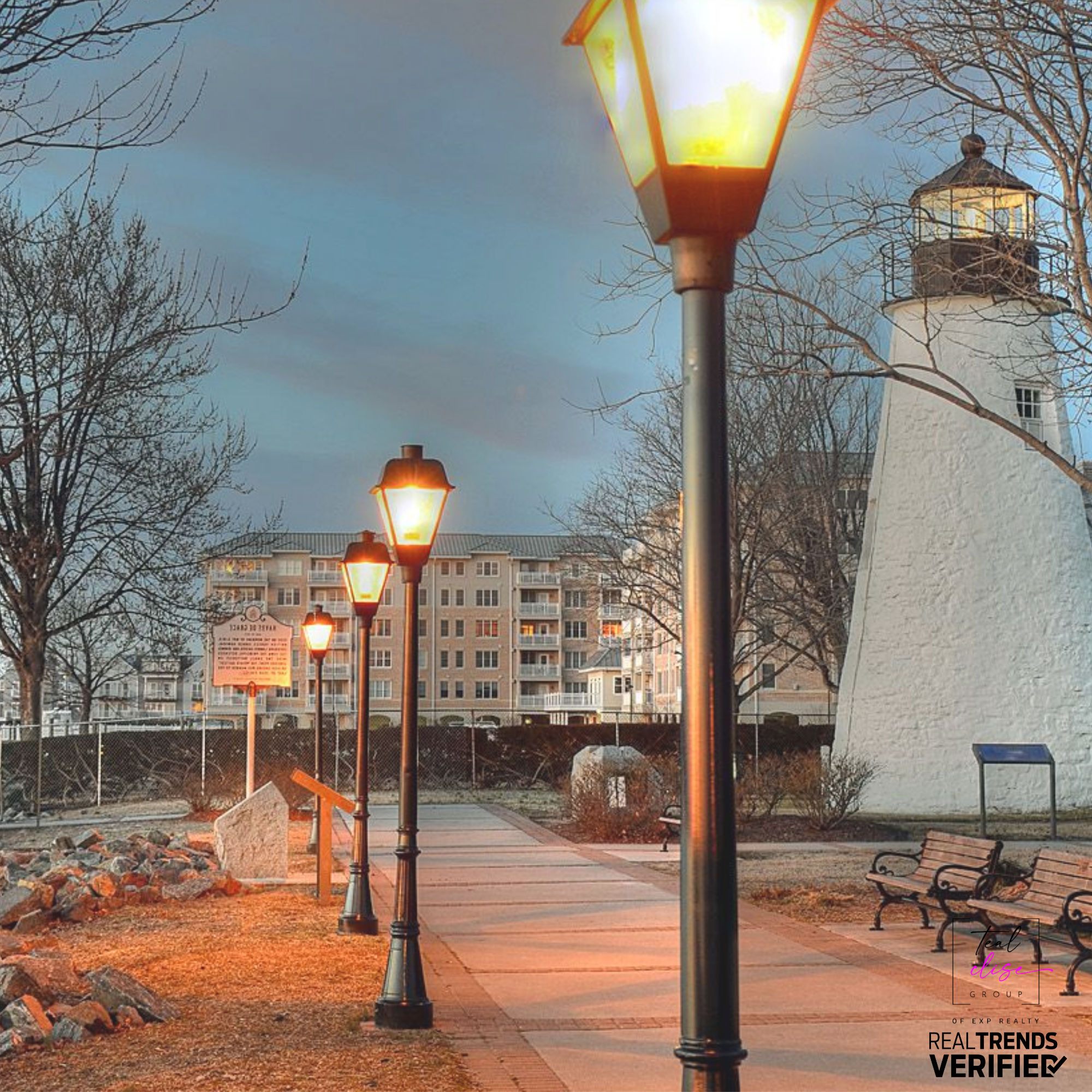 Scenic evening view of the Havre de Grace Promenade in Harford County, Maryland, with historic lighthouse, glowing street lamps, and waterfront walkway.