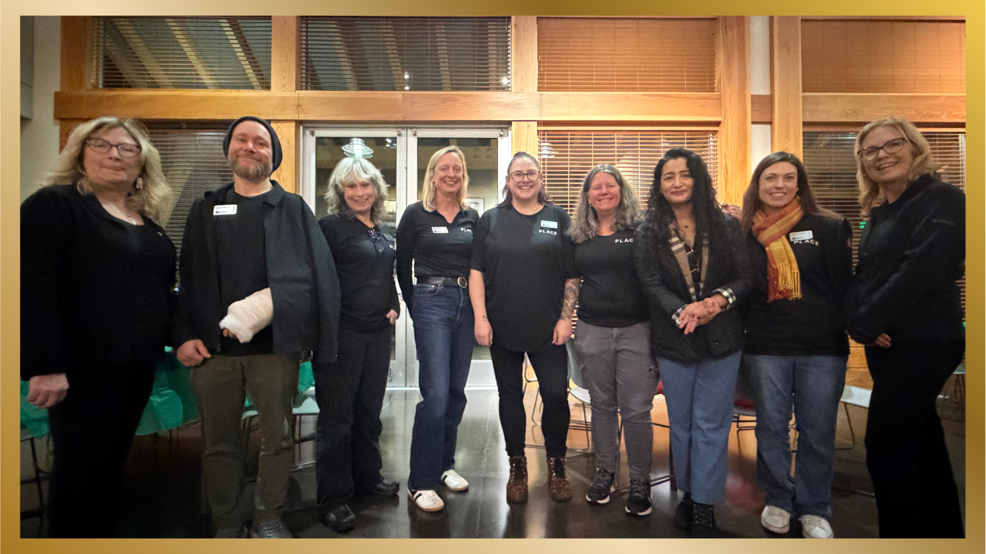 Nine members of the Satushek Real Estate Team standing in a line and smiling