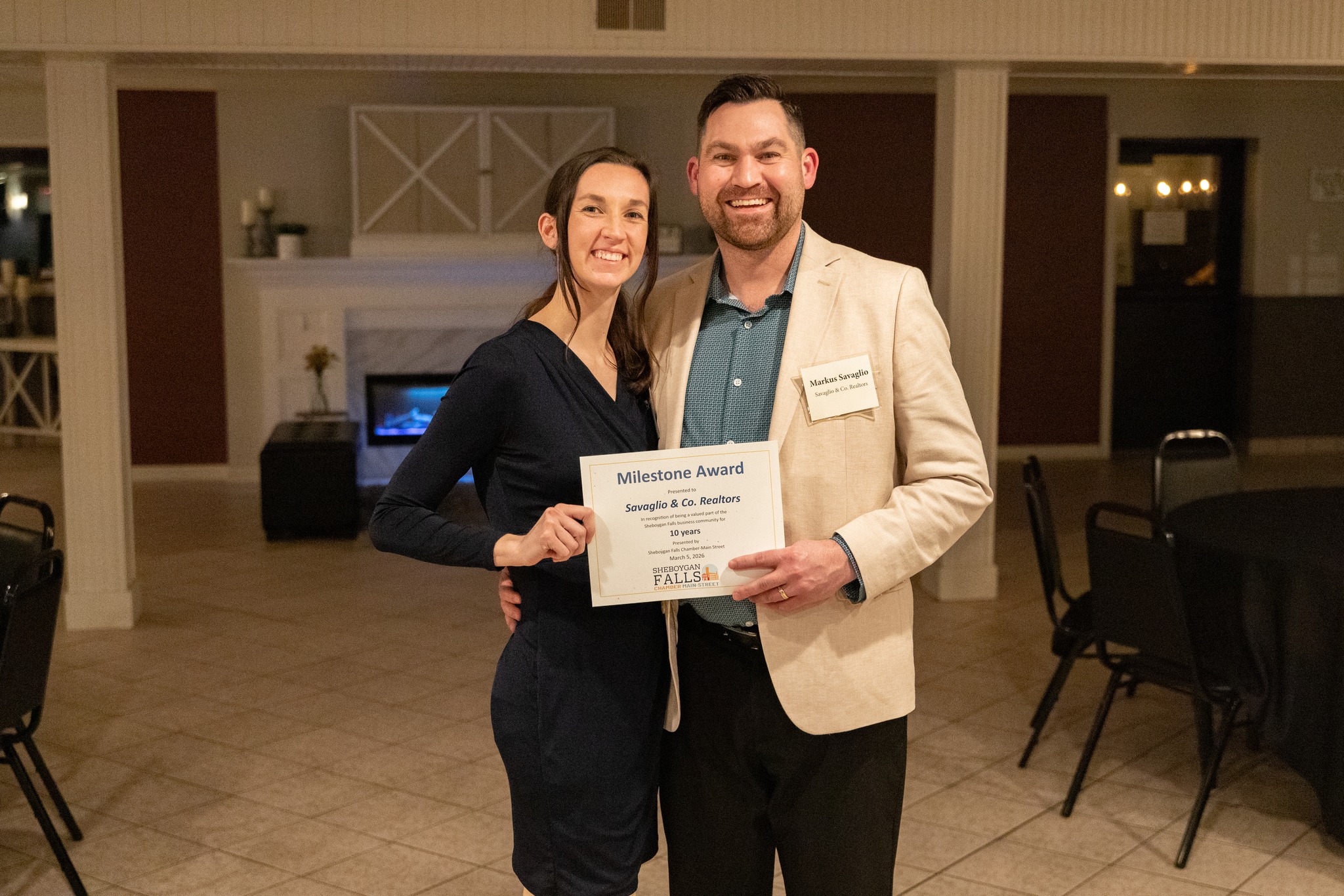 Markus and Jillian Savaglio holding a certificate celebrating 10 years in business