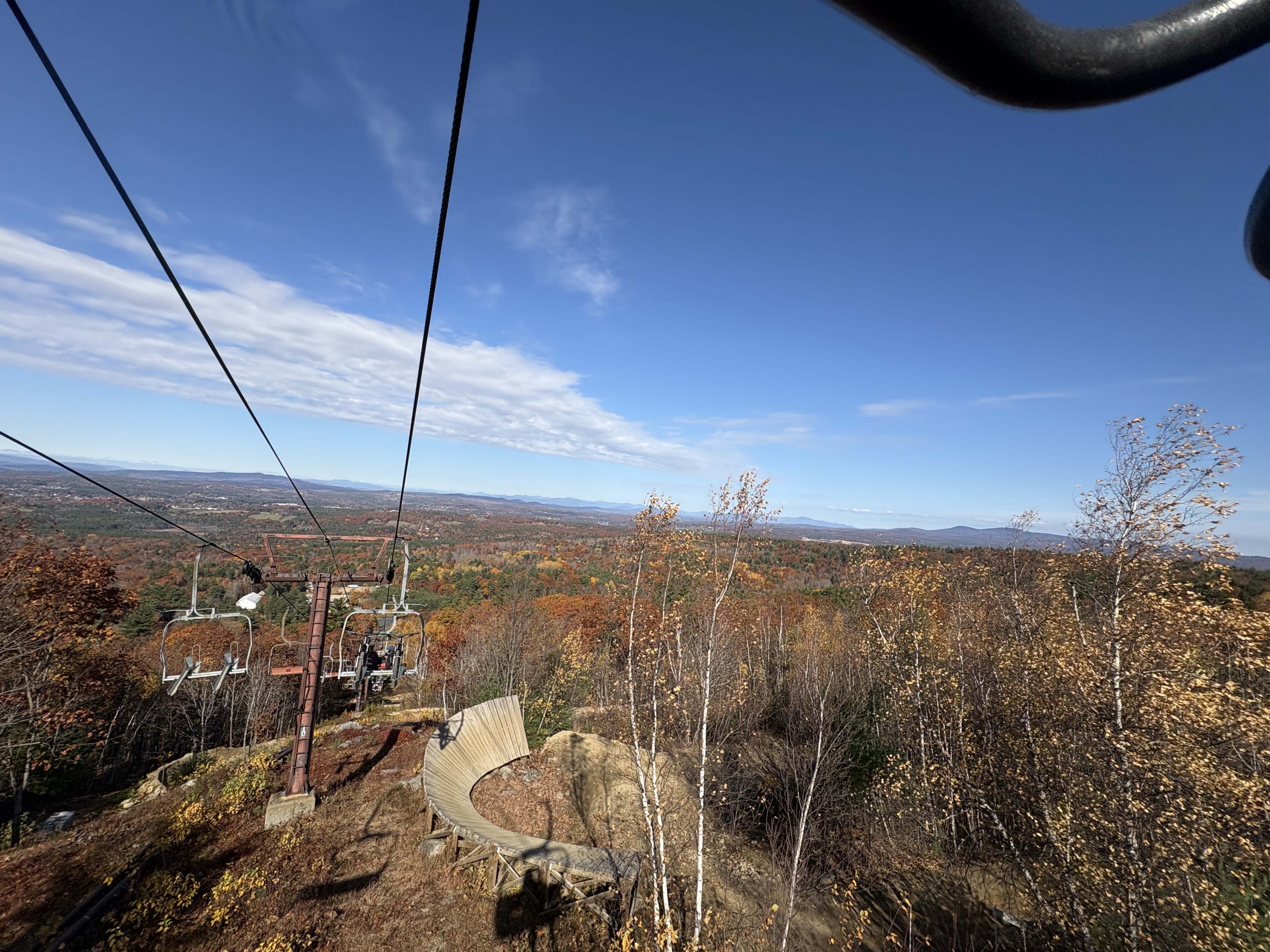 Looking backwards from the lift down the mountain, in the foreground is a wooden shark fin feature, behind it shows the fall foliage