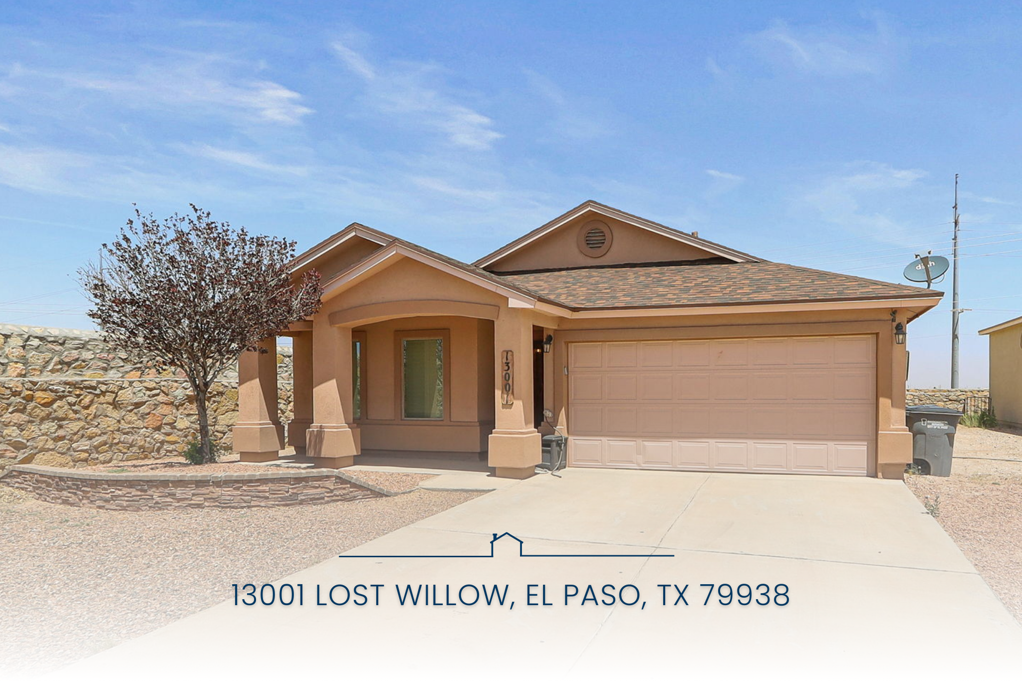 Front view of 13001 Lost Willow, a single-story home for sale in East El Paso, TX, featuring a two-car garage, desert landscaping, and stone wall fencing.