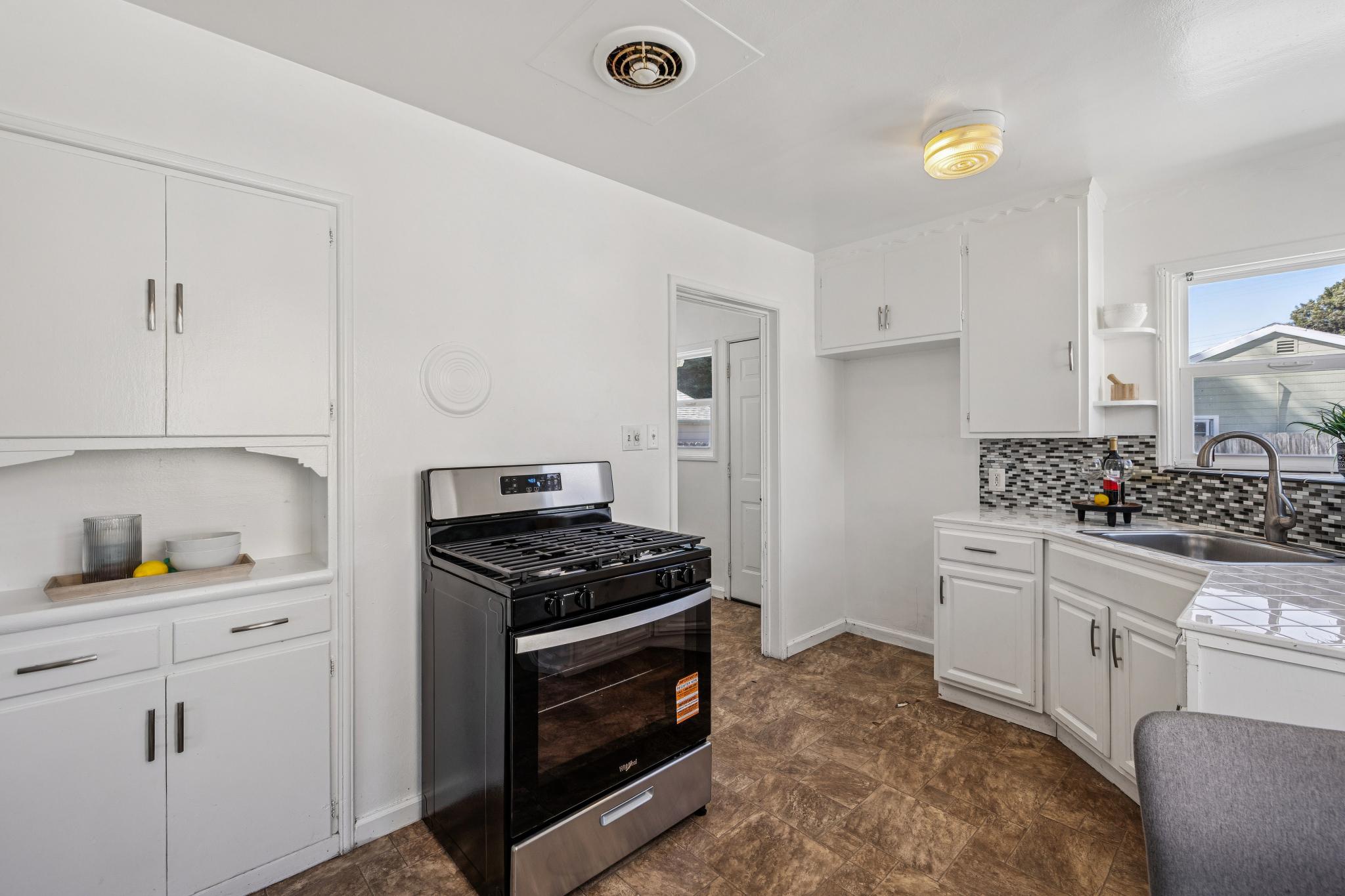 Kitchen with white cabinets and new gas range at 3417 Maricopa Ave in Richmond, CA