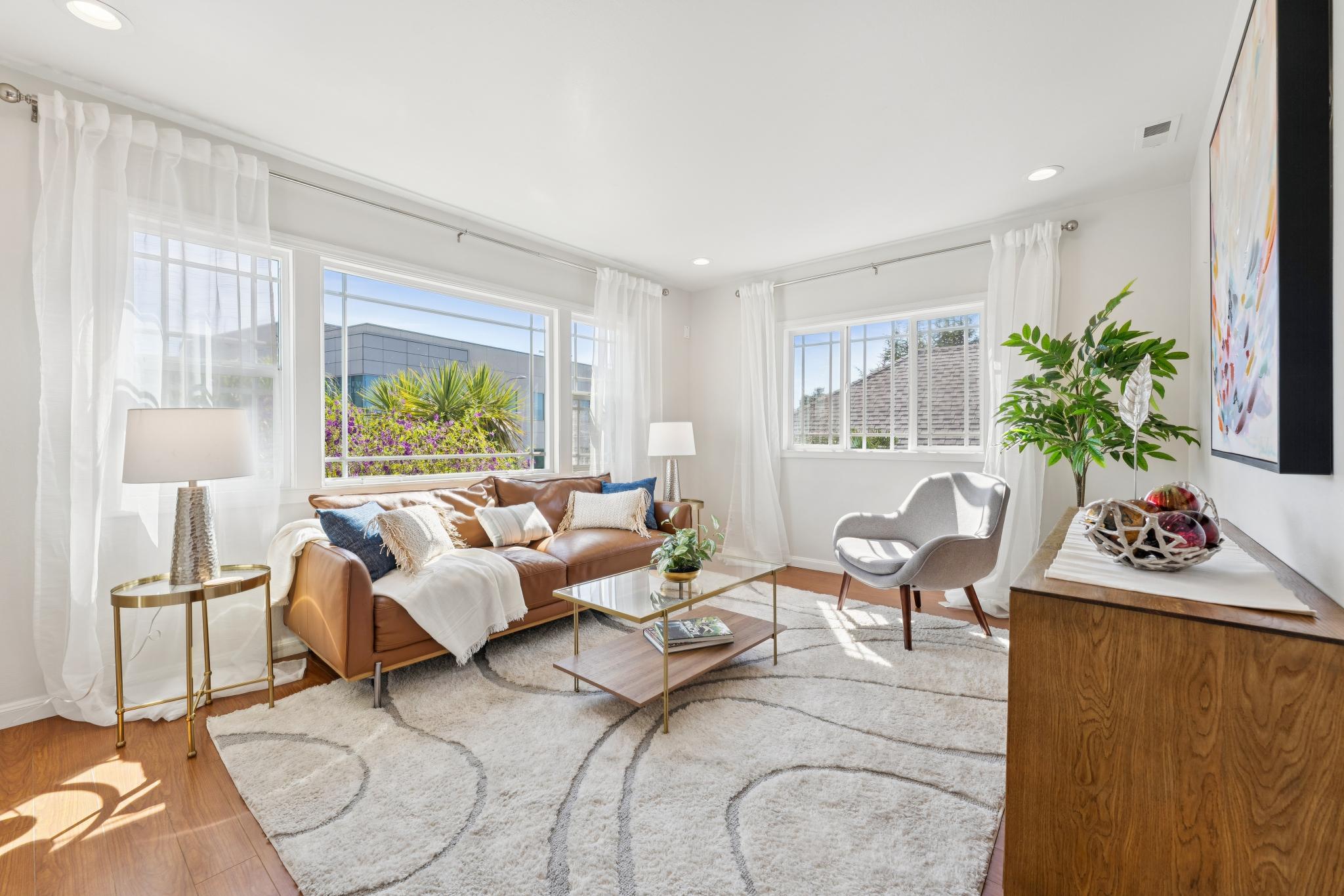 Bright living room with wide front windows at 1390 E 31st St in Oakland, CA