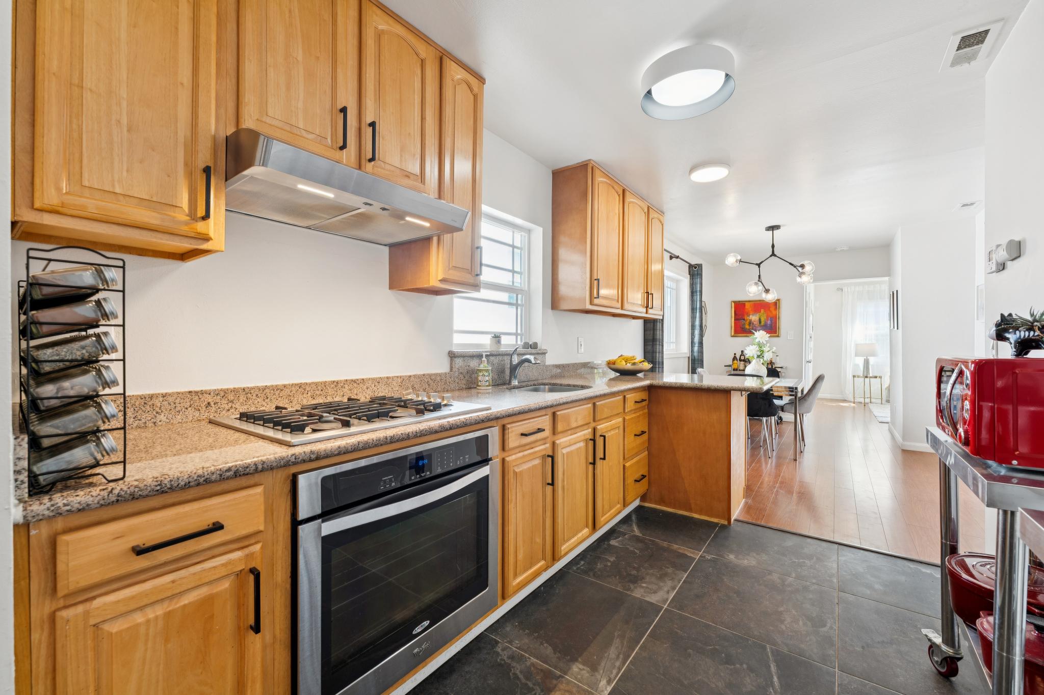 Eat-in kitchen with wood cabinetry and gas cooktop at 1390 E 31st St in Oakland, CA