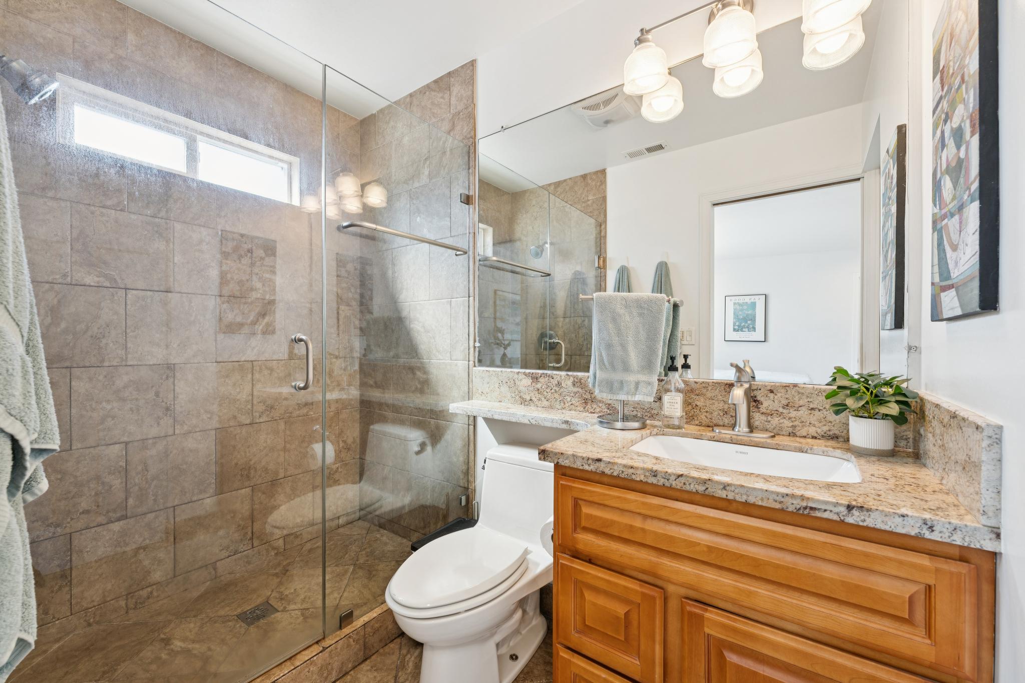 Primary bathroom with glass-enclosed tiled shower at 1390 E 31st St in Oakland, CA