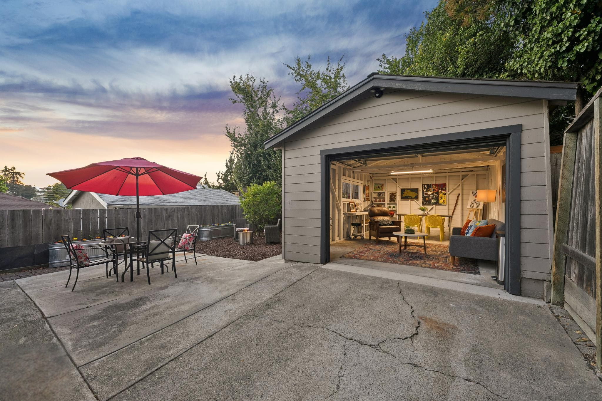 Rear patio and detached garage at 1390 E 31st St in Oakland, CA, with outdoor dining area and fenced yard.