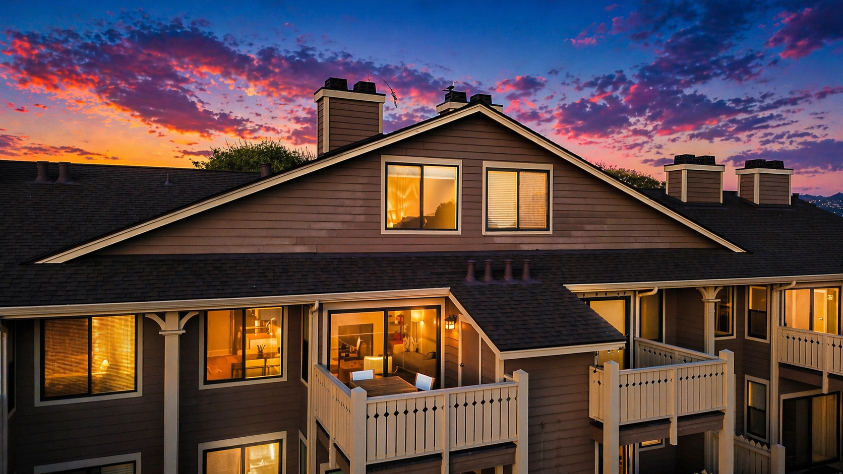 Twilight exterior of 194 Lakeshore Ct in Marina Bay, Richmond, showing the condo building, private balcony, glowing interior lights, and colorful sunset sky.
