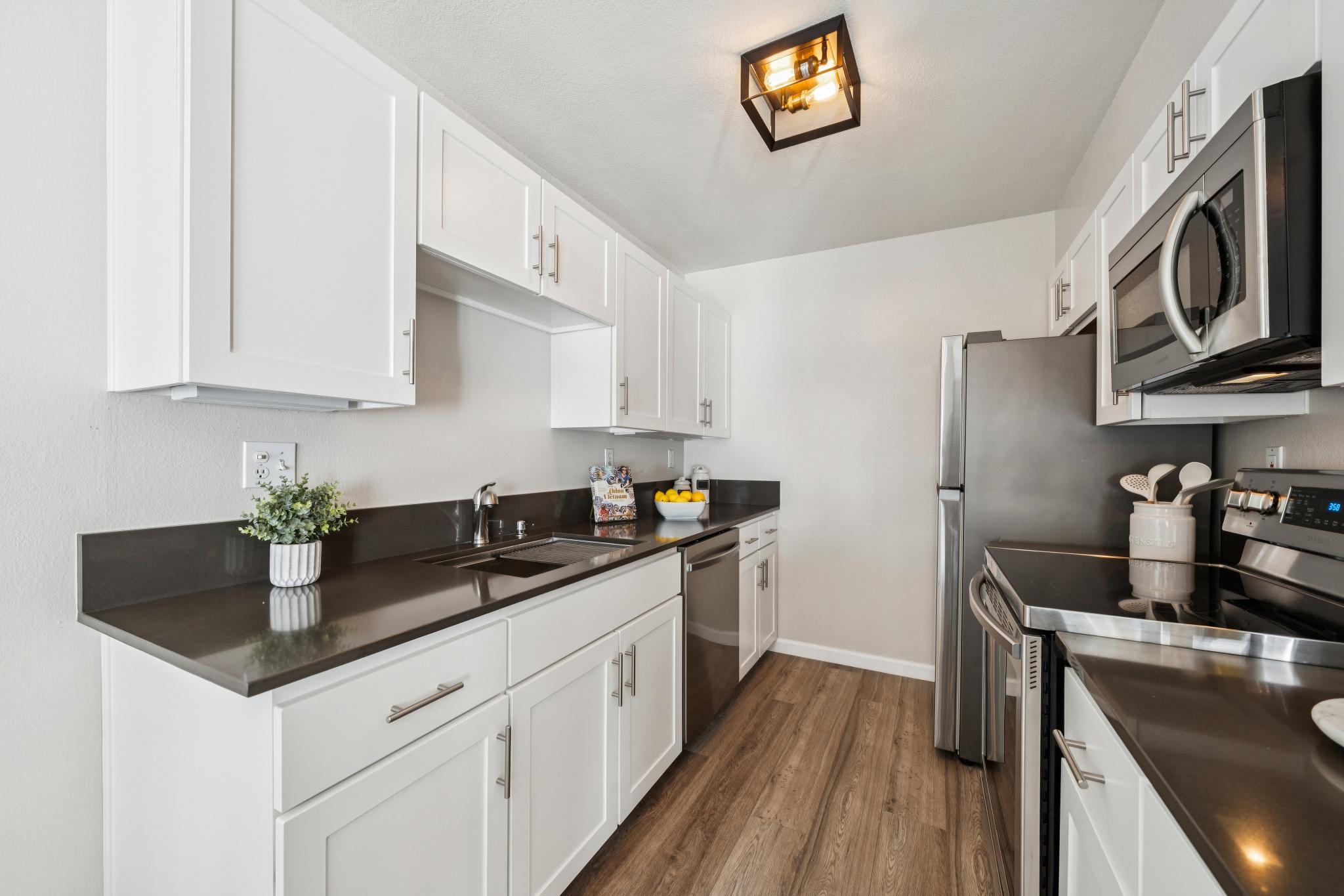 Galley kitchen with white cabinets and stainless steel appliances at 214 Bayside Ct in Richmond, California