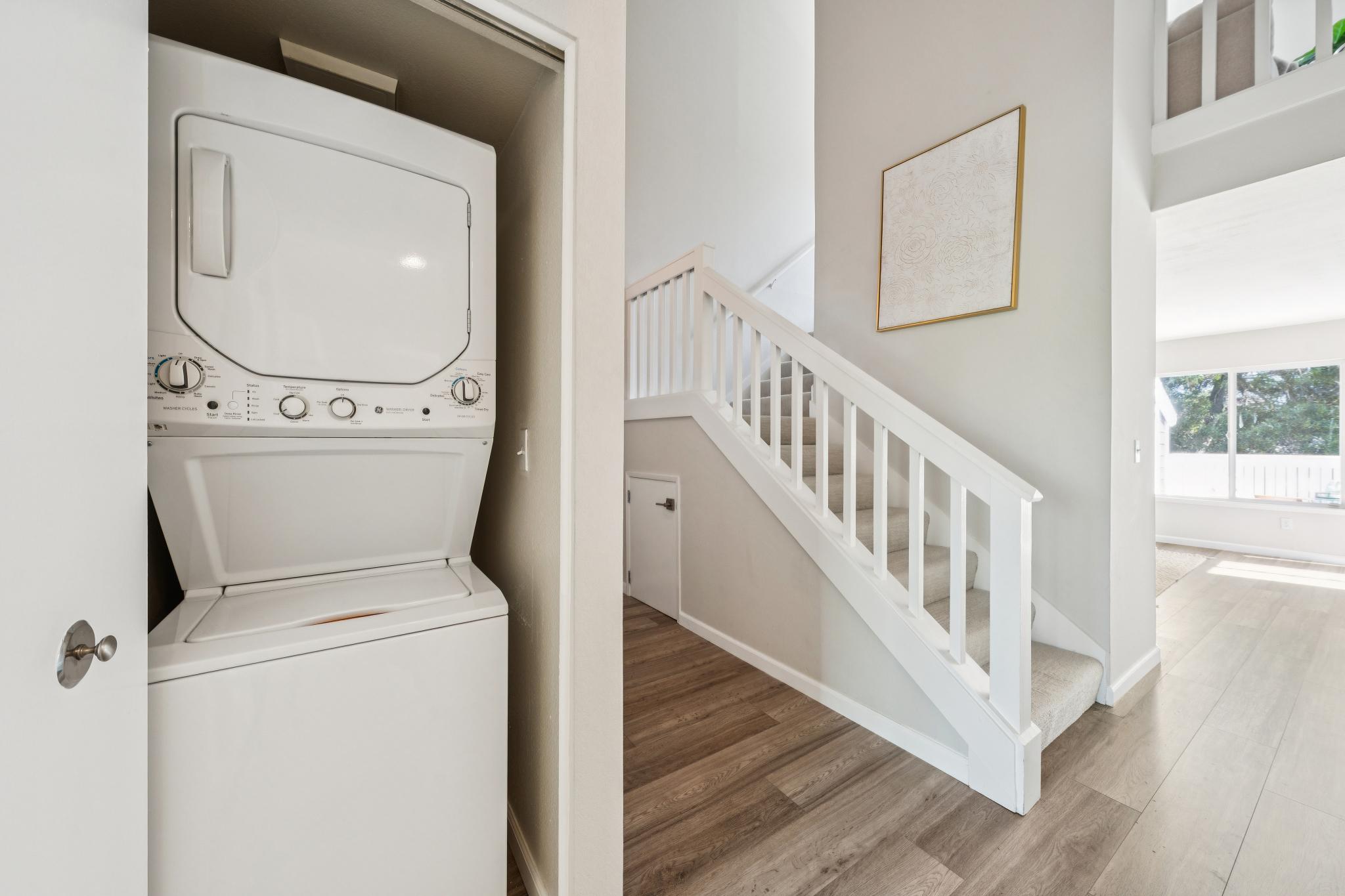 In-unit stacked laundry closet beside the stairs at 214 Bayside Ct in Richmond, California