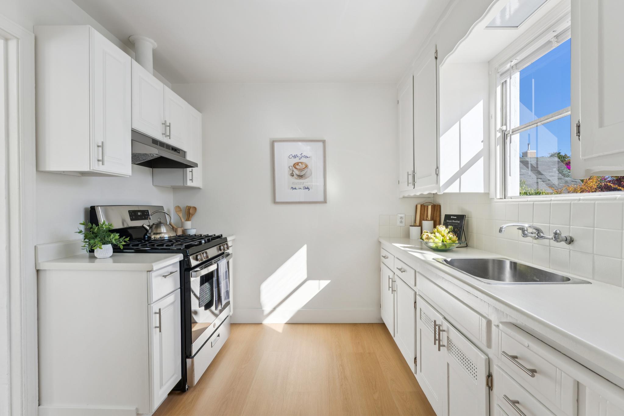 Kitchen with white cabinets, gas range and window over the sink at 3400 McBryde Ave in North and East, Richmond, CA