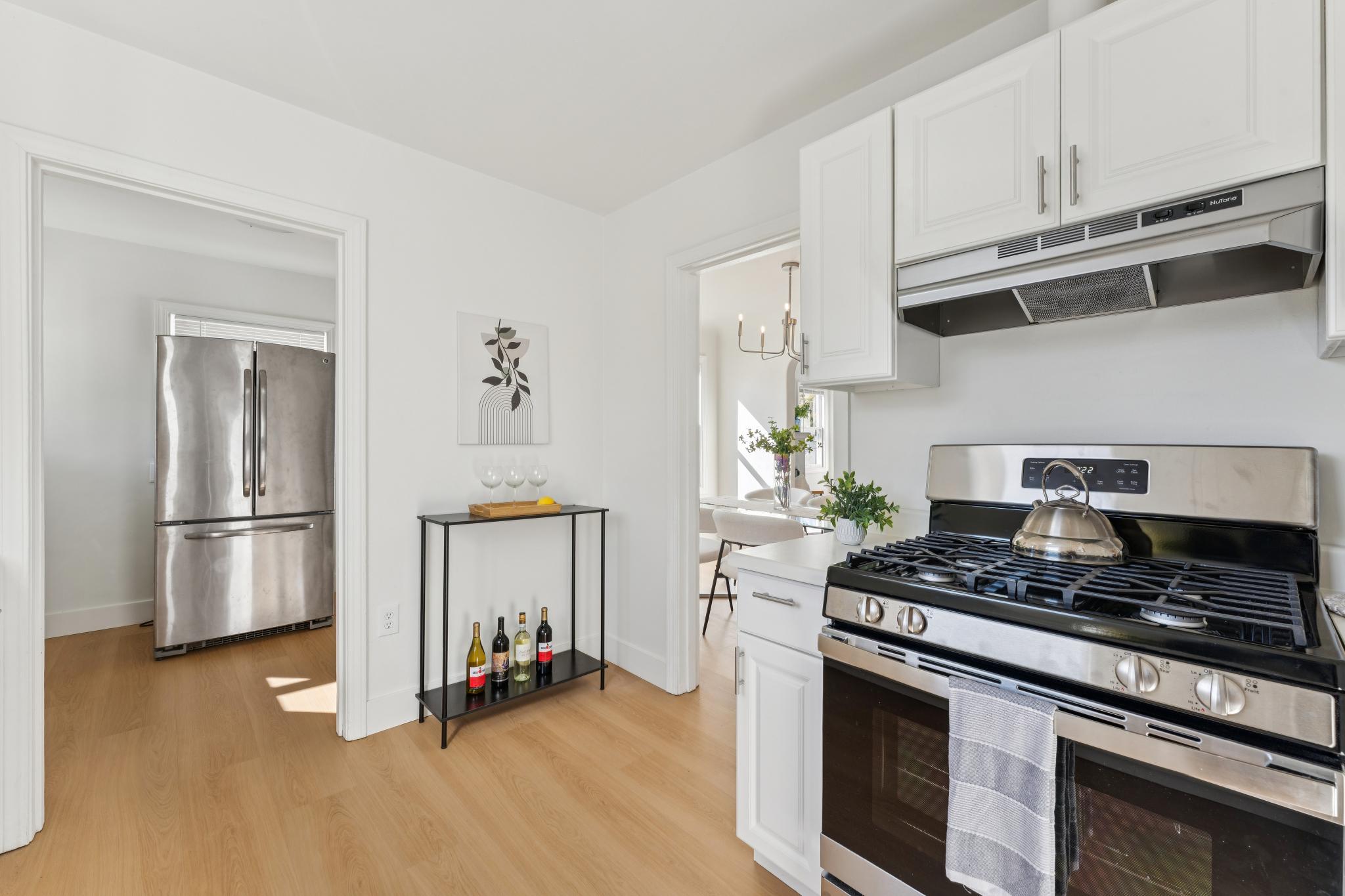 Kitchen showing gas range, refrigerator and white cabinets at 3400 McBryde Ave in North and East, Richmond, CA