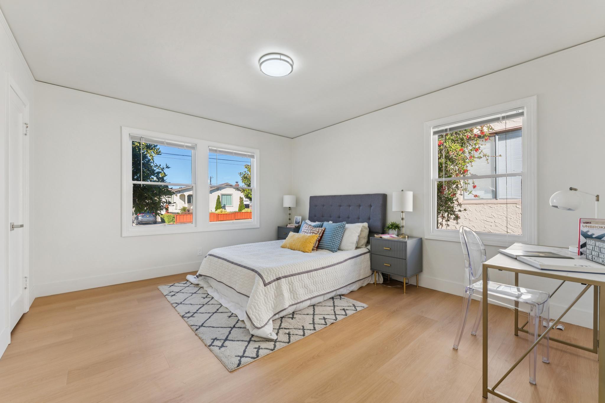 Second bedroom with two windows and wood-look flooring at 3400 McBryde Ave in North and East, Richmond, CA
