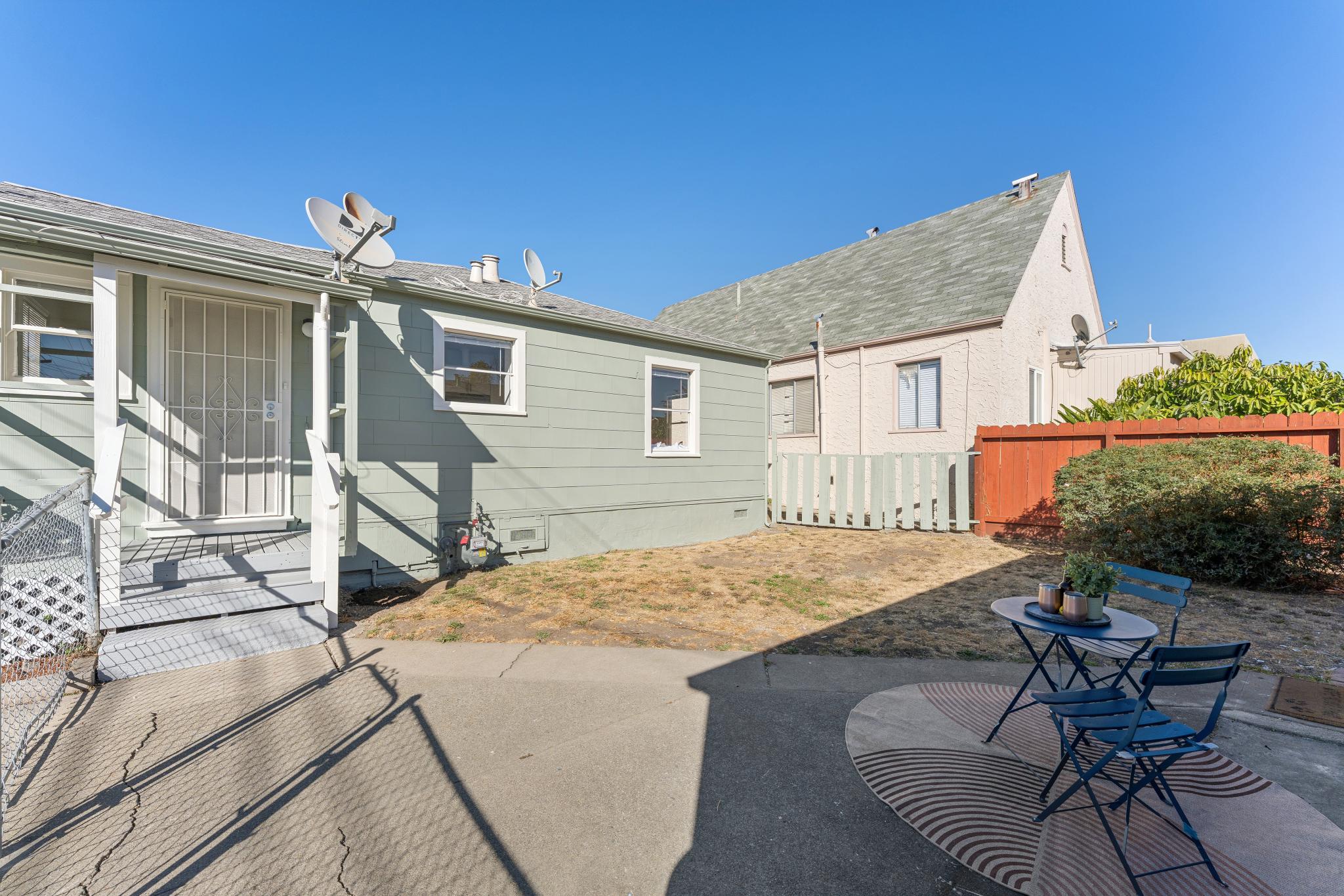 Backyard with paved seating area beside the house and detached garage at 3400 McBryde Ave in North and East, Richmond, CA