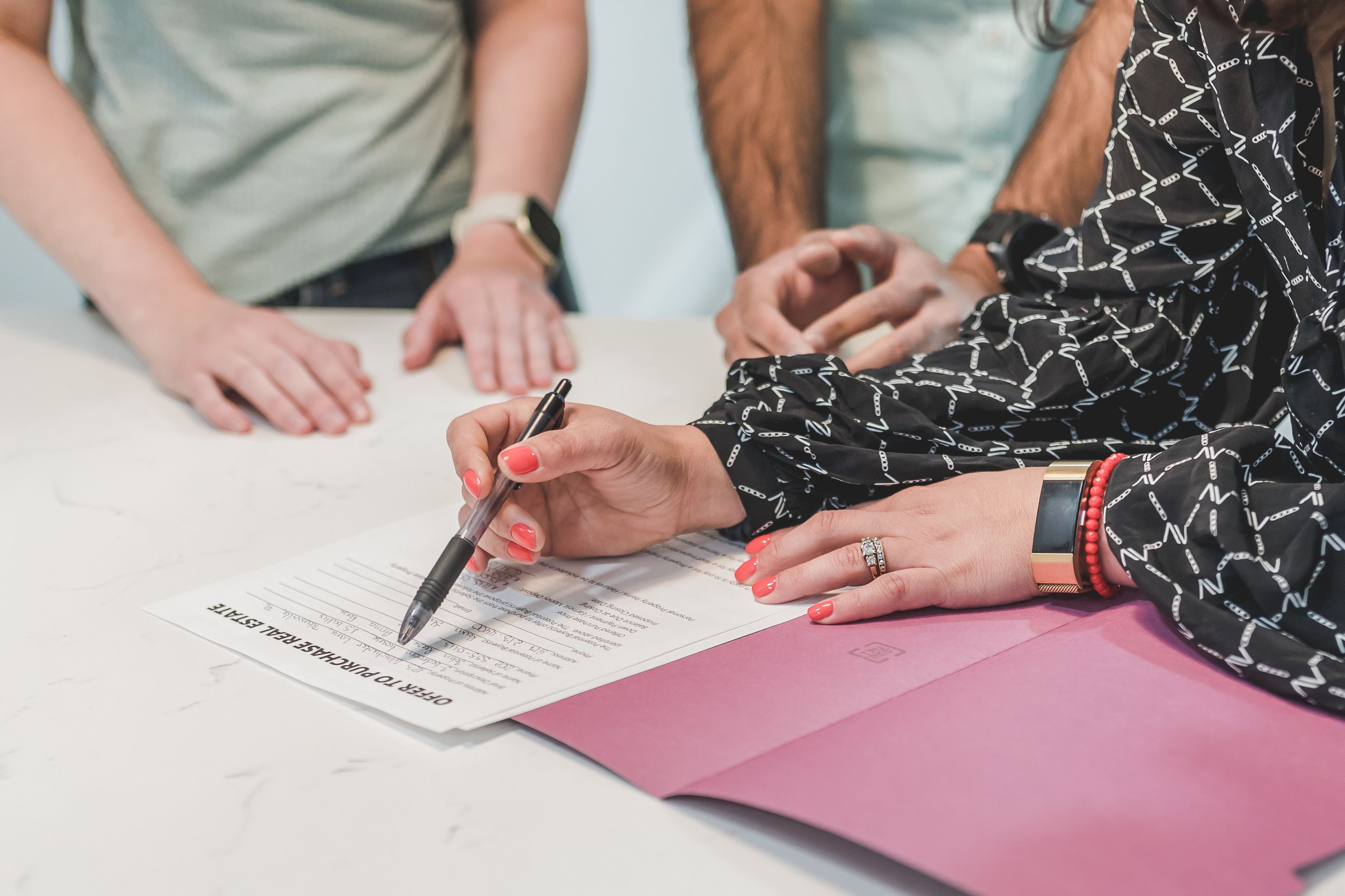 Real estate professional reviewing an offer document with clients during a property consultation.