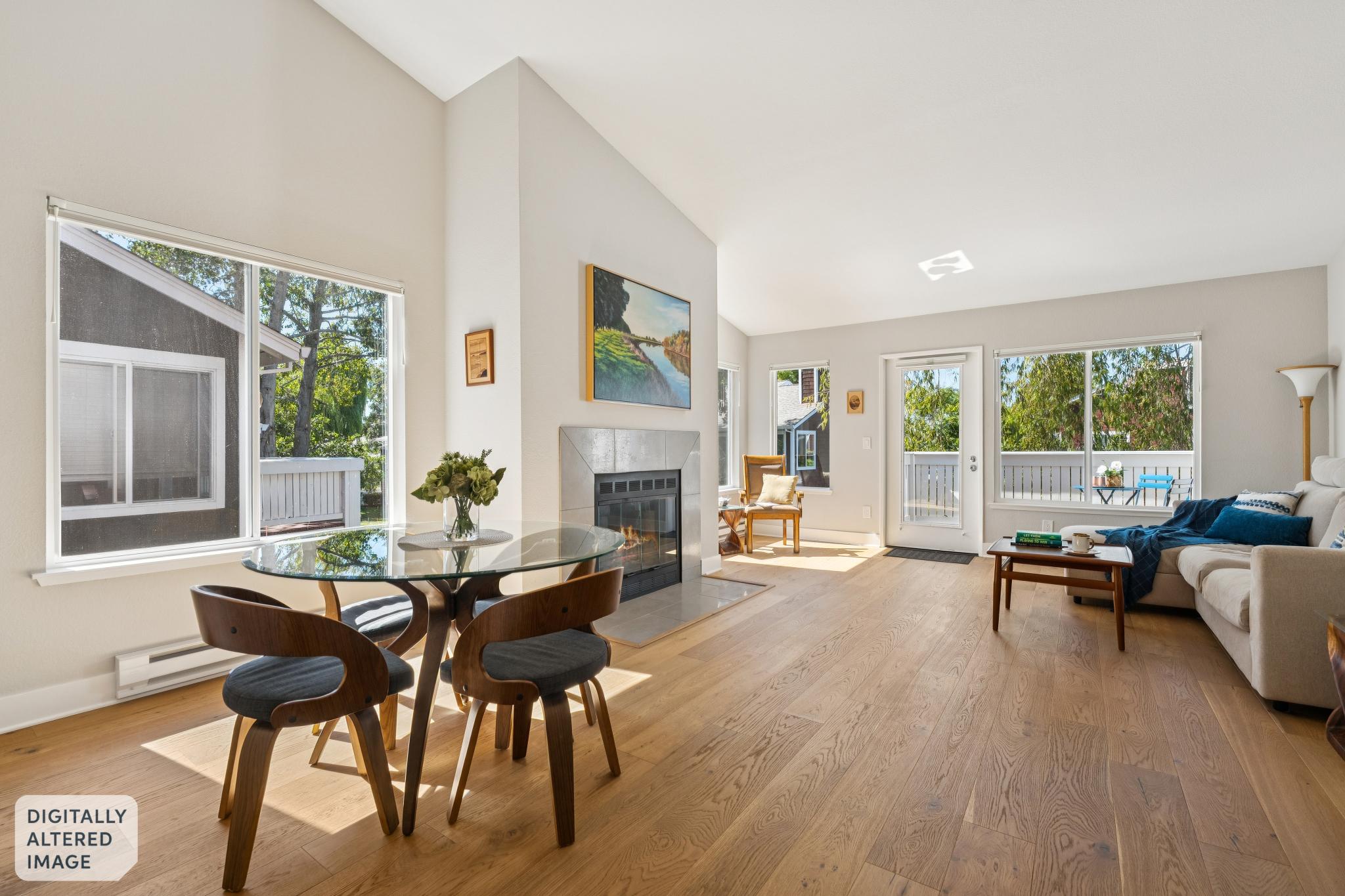 Bright open living and dining area with fireplace lit at 12 Bayside Ct in Marina Bay, Richmond