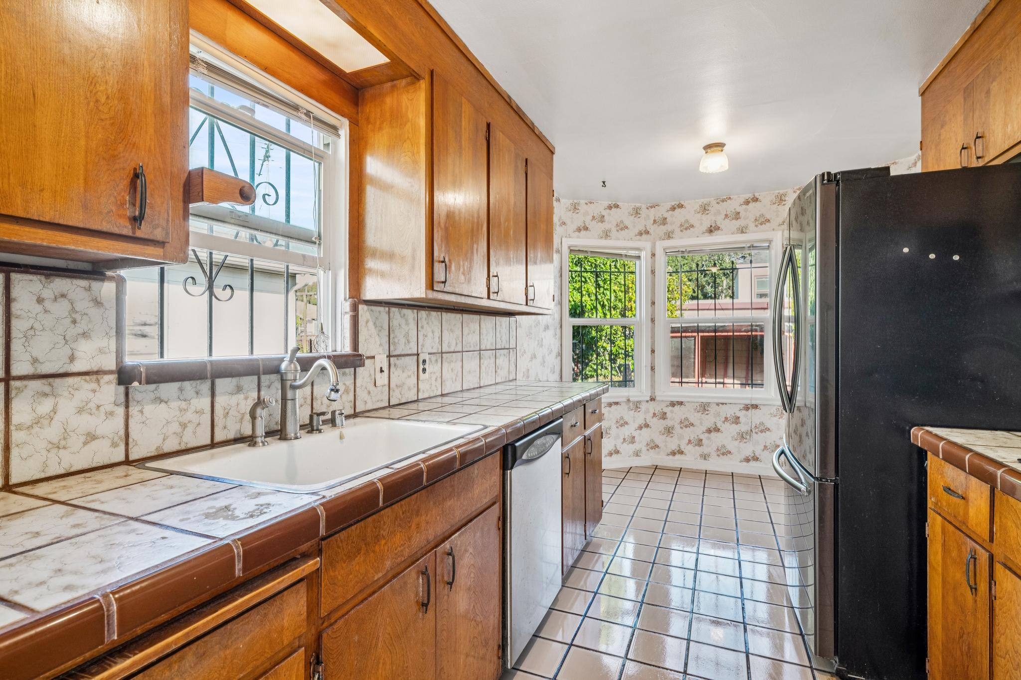 Kitchen with wood cabinets, tile counters and breakfast nook at 974 33rd St, North and East, Richmond