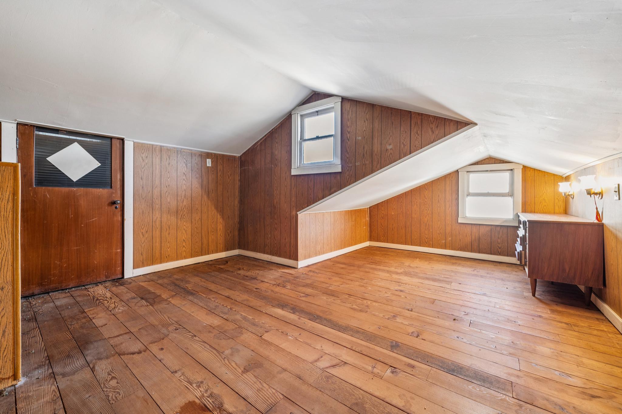 Attic bonus room with sloped ceiling and wood paneling at 974 33rd St, North and East, Richmond
