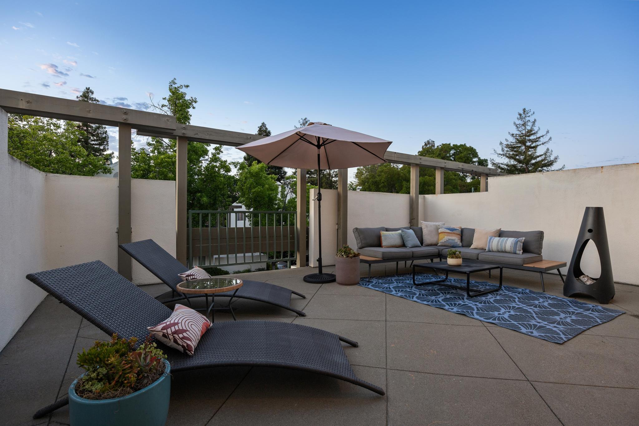 Private patio at 36 Mozden Ln in Pleasant Hill with lounge chairs, outdoor sofa, umbrella, and seating area.