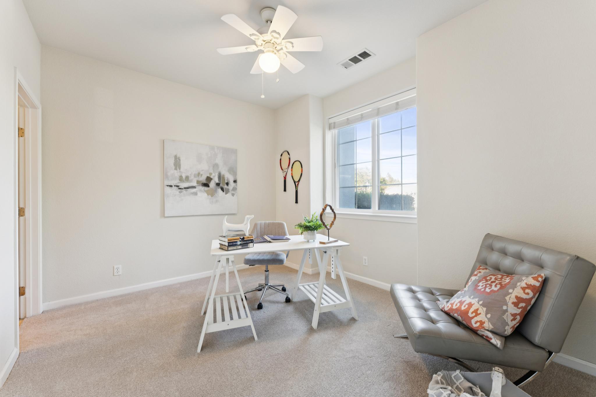 Entry-level bedroom staged with a desk and sofa at Jetty Drive in Marina Bay, Richmond