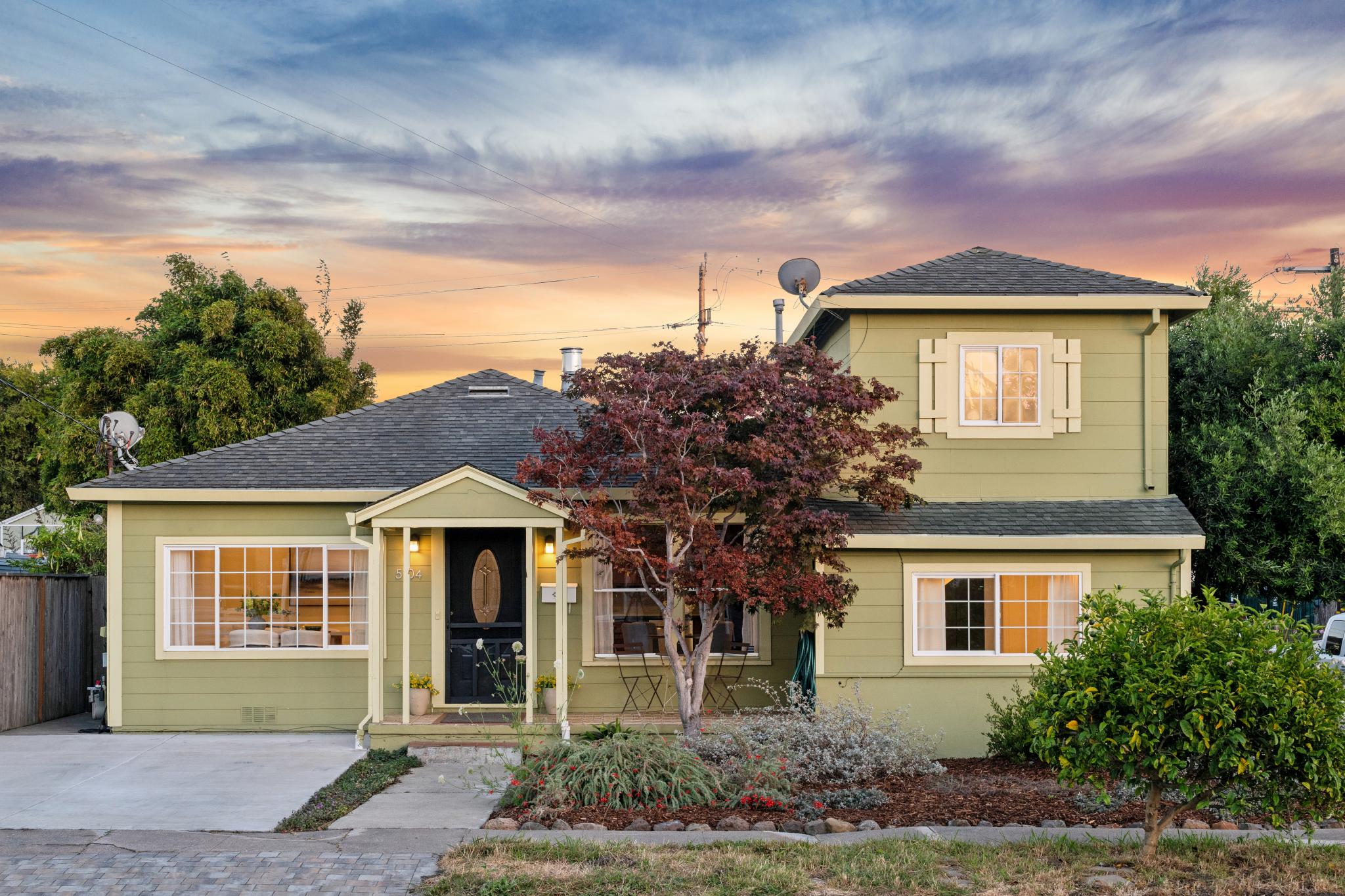Twilight front exterior of 5104 Tehama Ave in Richmond, CA, with green siding, a covered porch, and mature landscaping.
