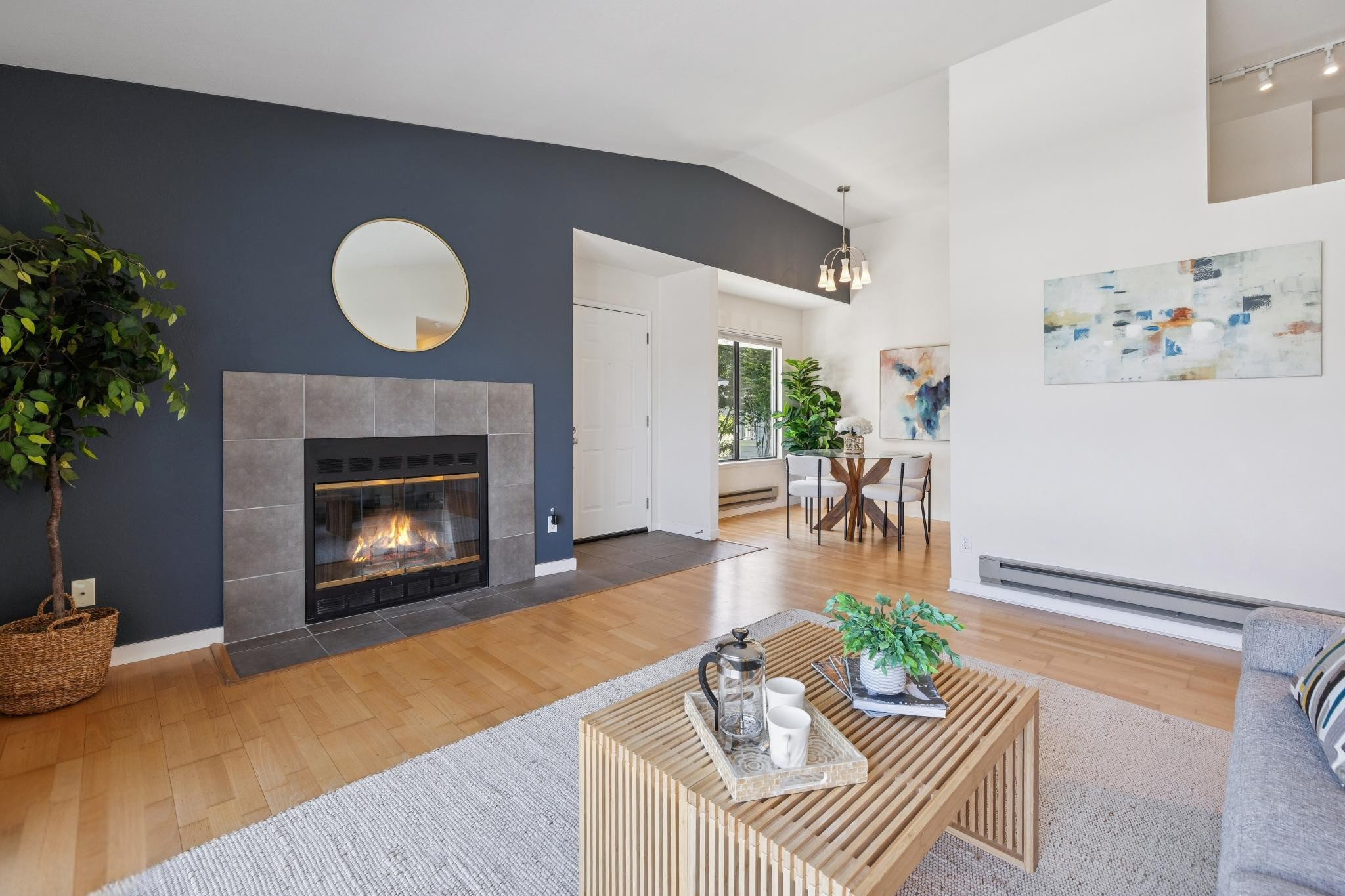 Living room with fireplace, hardwood floors, and adjacent dining area at 6 Schooner Ct in Marina Bay, Richmond.