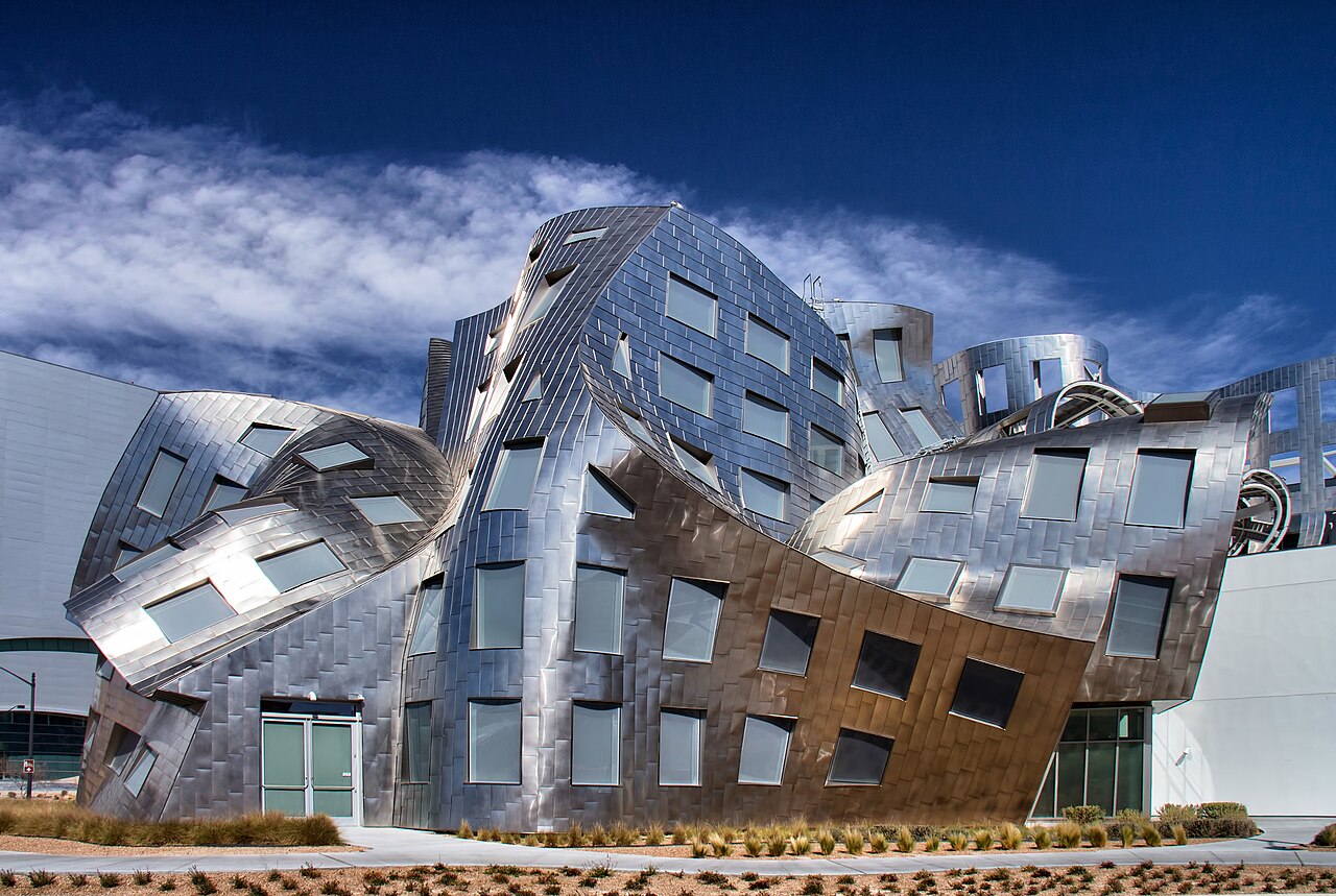 Curved stainless-steel exterior of the Cleveland Clinic Lou Ruvo Center for Brain Health in Las Vegas under a blue sky with wispy clouds