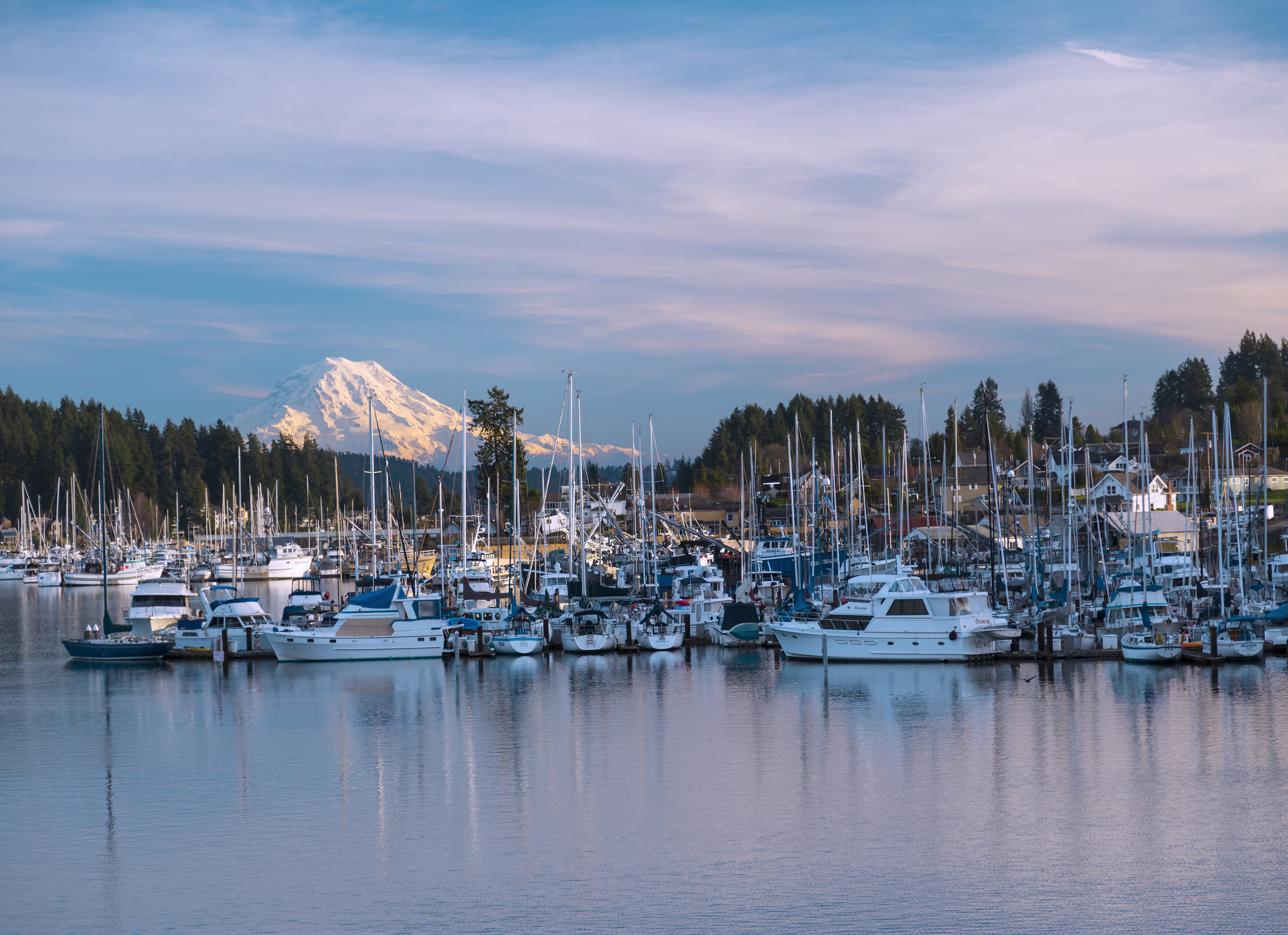 Gig Harbor marina with boats and Mount Rainier in the background, showcasing waterfront lifestyle and real estate in Gig Harbor Washington