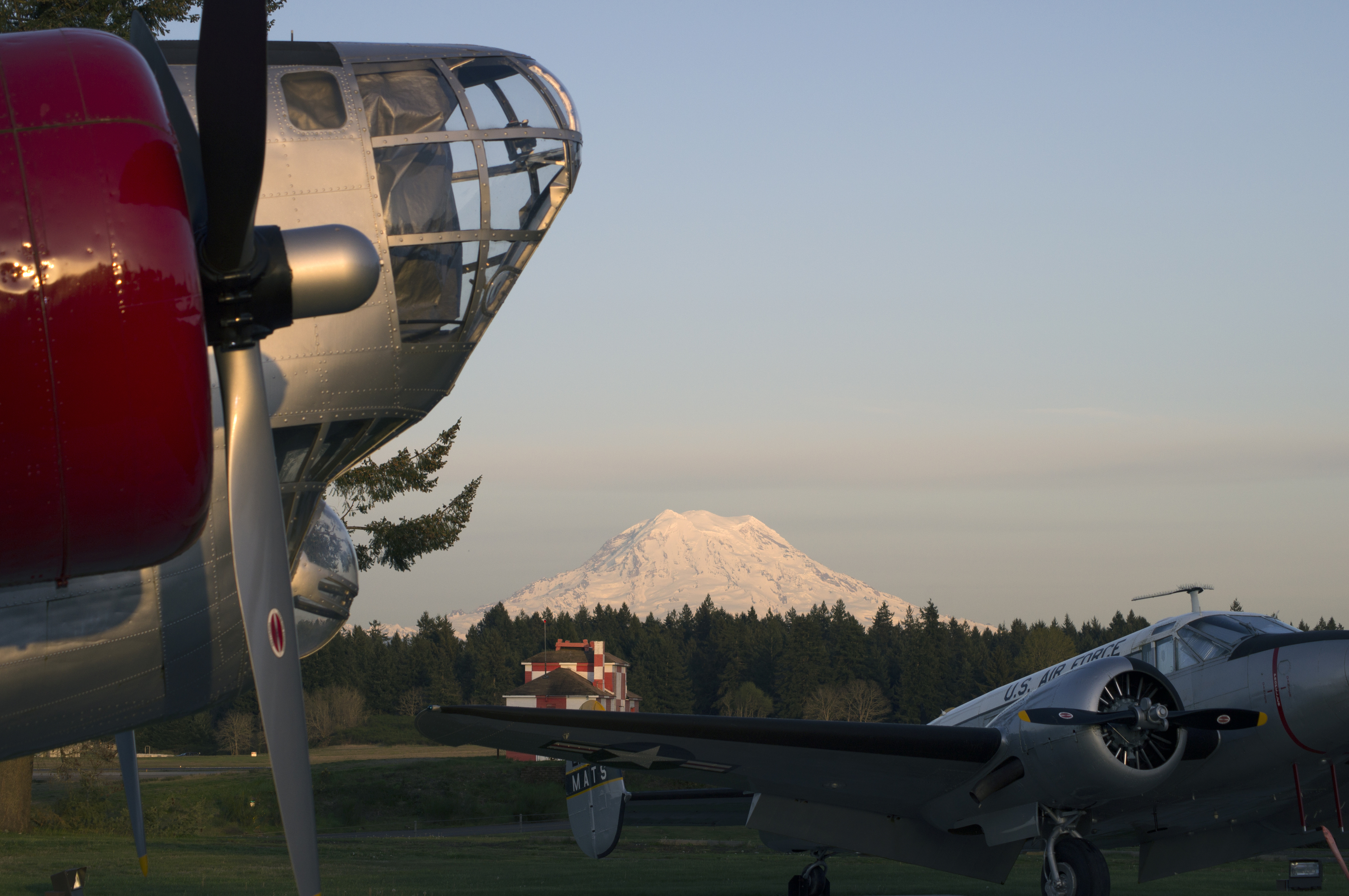 Historic military aircraft displayed at Joint Base Lewis-McChord (JBLM) with Mount Rainier in the background, representing military life and relocation to Western Washington.