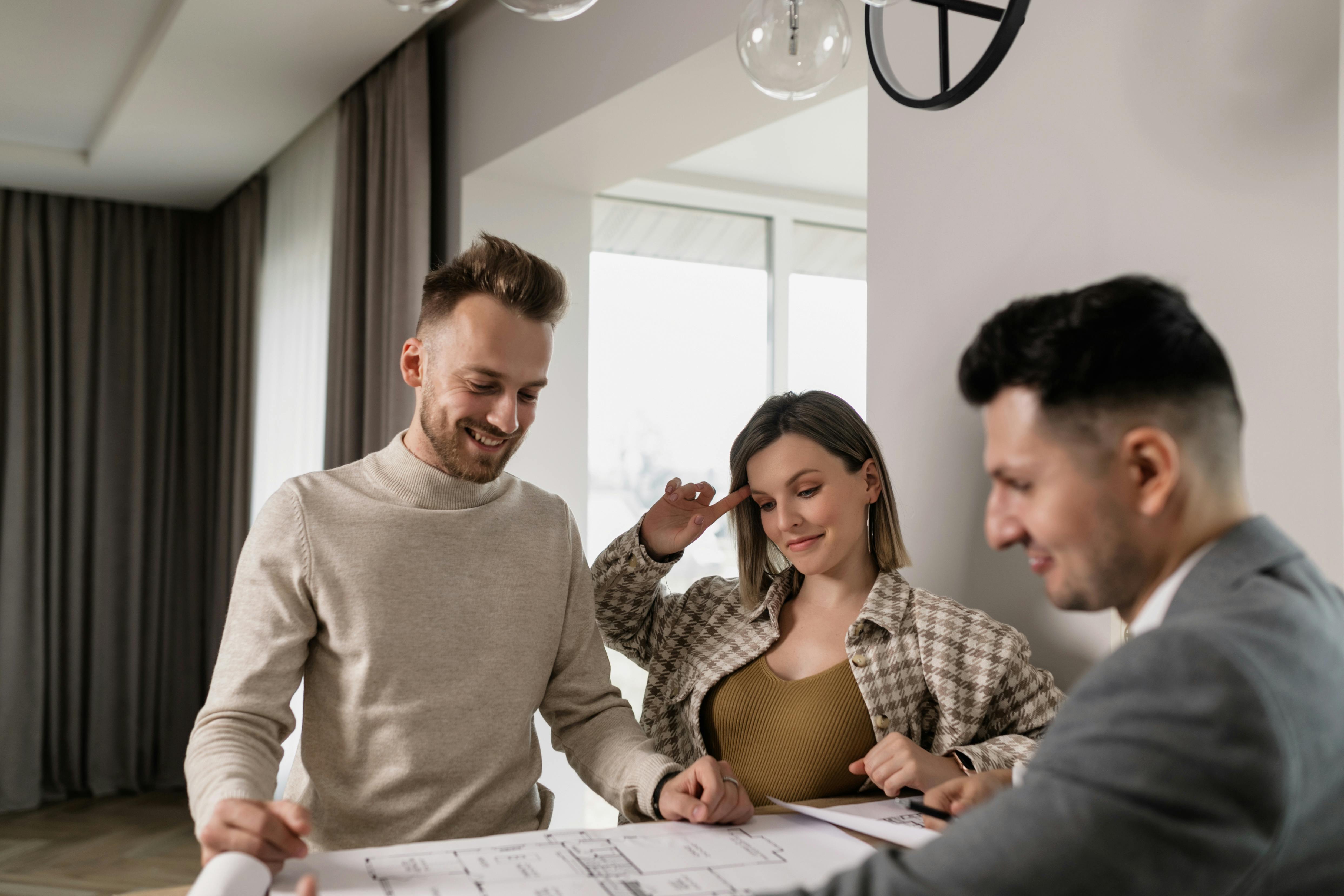 A couple signing house documents with a realtor