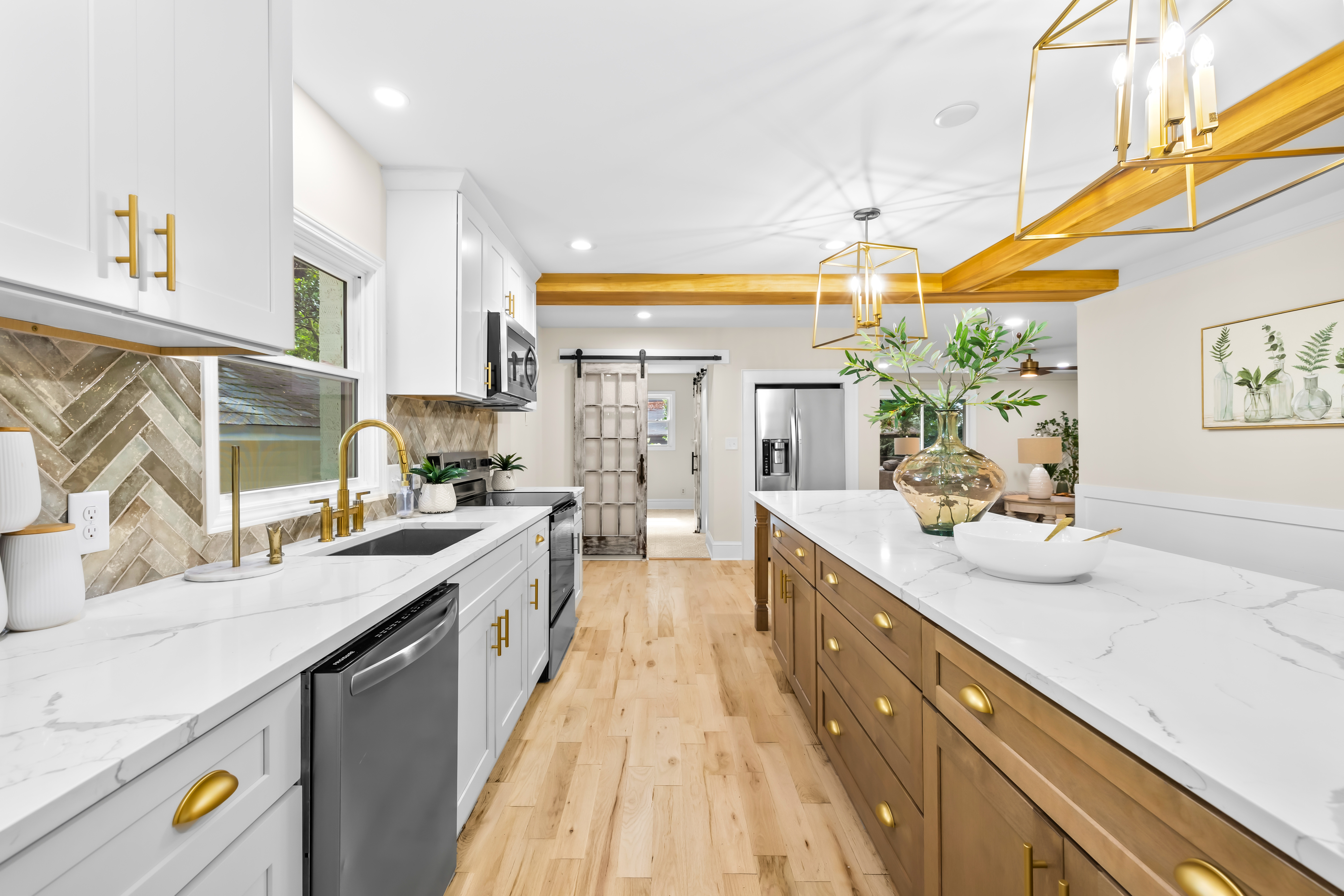 Modernized kitchen in Concord NC with white shaker cabinets, quartz countertops, and stainless steel appliances.