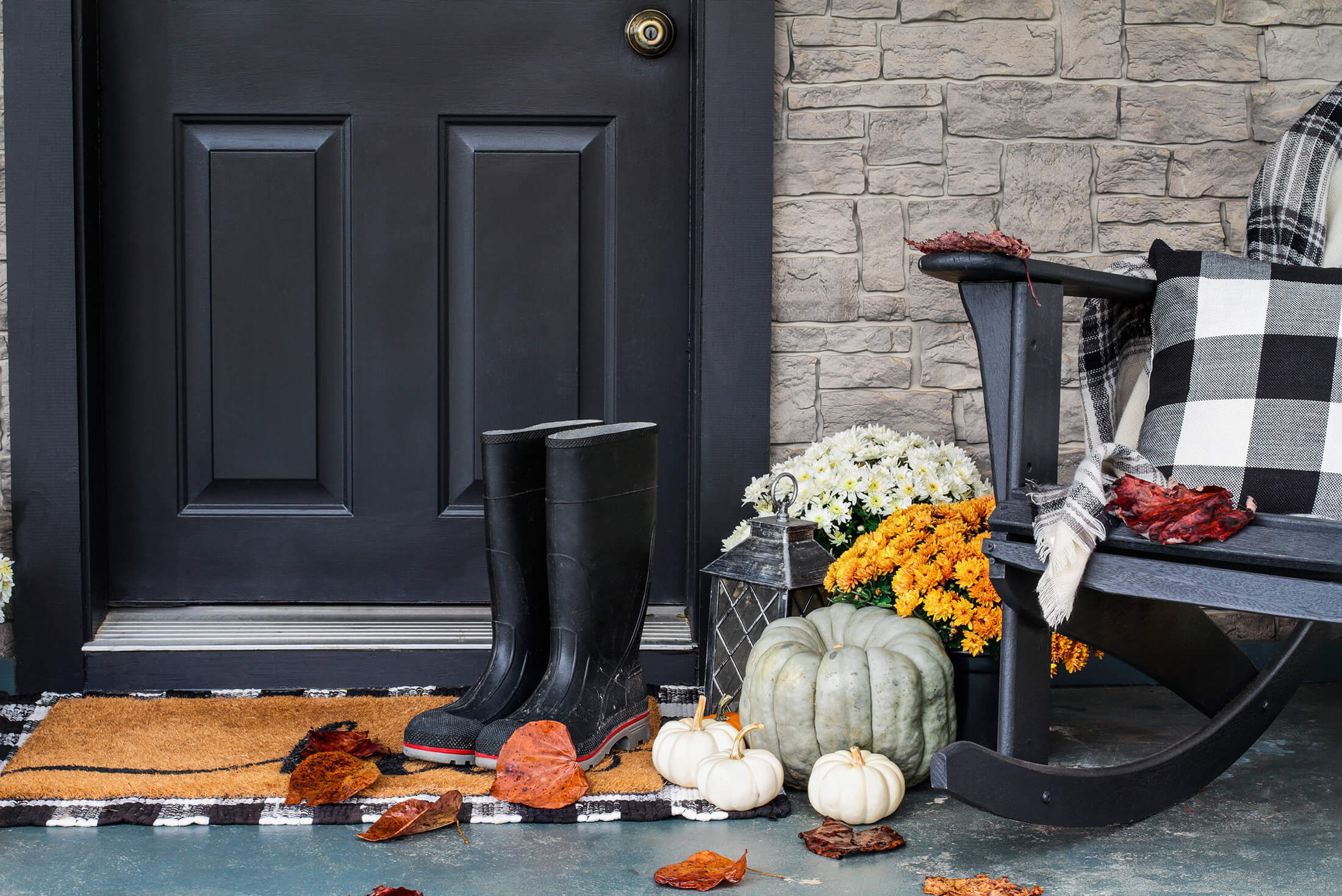 A tidy entryway with a boot tray, a bench, and a basket of shoe covers on a snowy day.