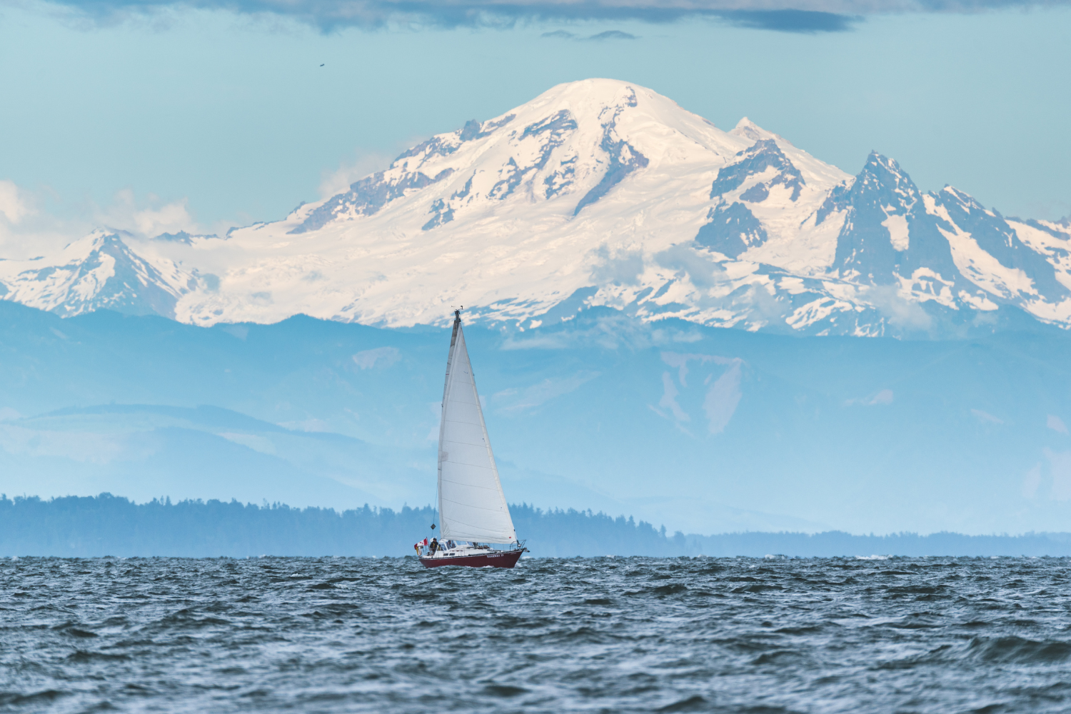 A sail boat in front of Mount Baker