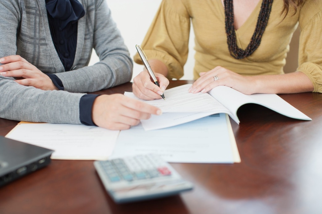 Professional image of a confident businesswoman (representing expertise and professionalism) in front of Las Vegas homes, or an image showing a balanced scale with a house and legal gavel, symbolizing the intersection of real estate and family law.
