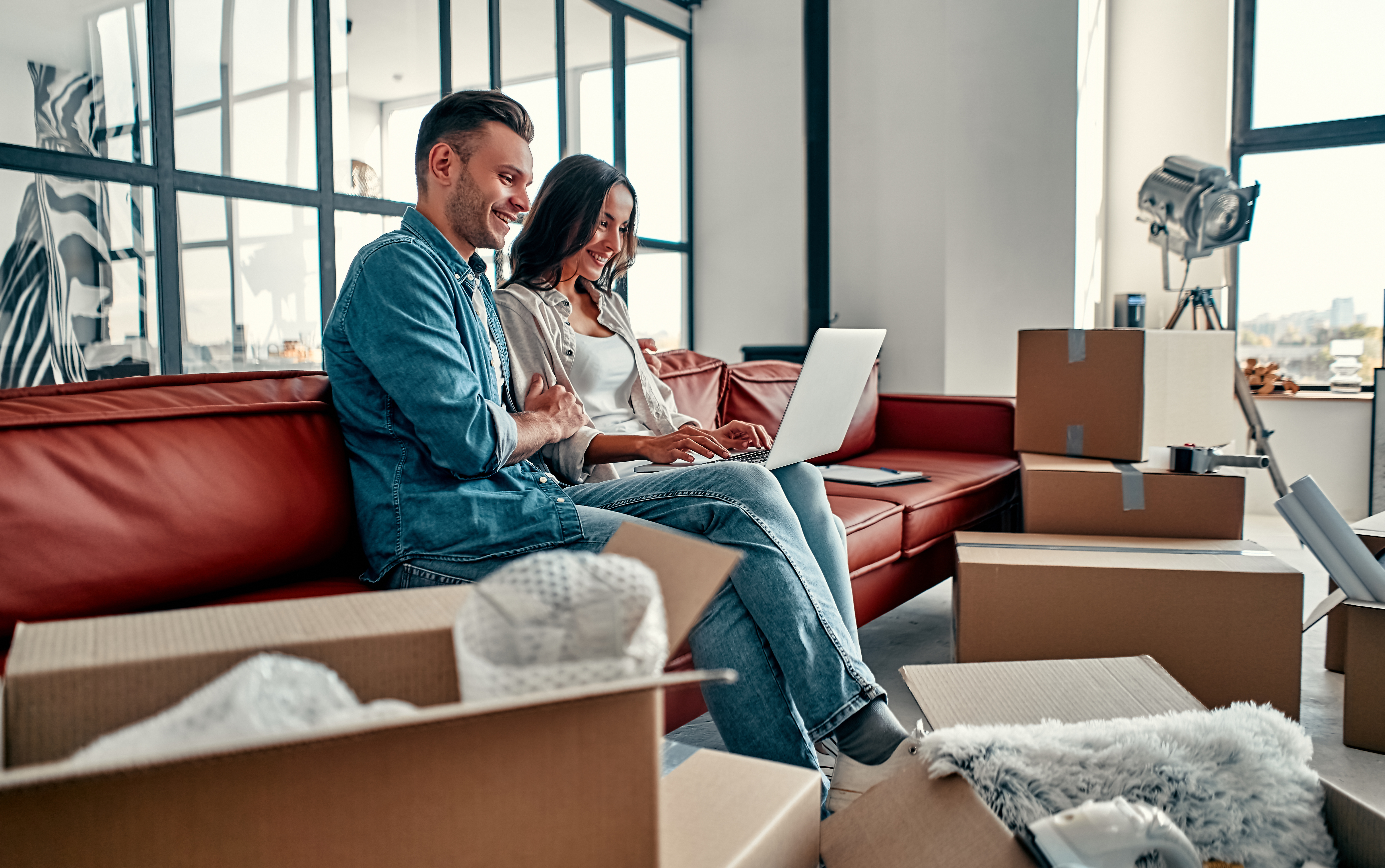 Couple looking at a computer while packing up their home.