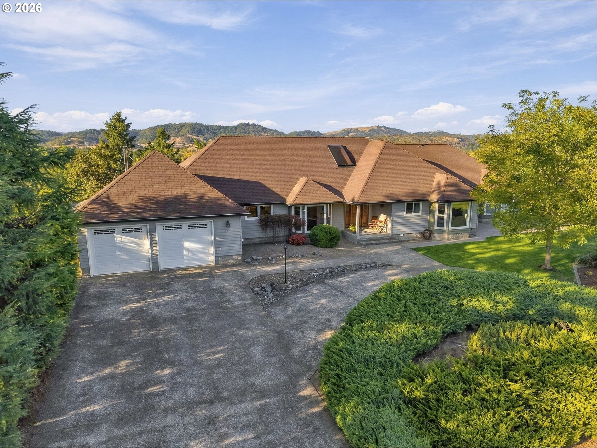 Front of the single-level home at 365 Birdie Ln in Roseburg with landscaped grounds and mountain views