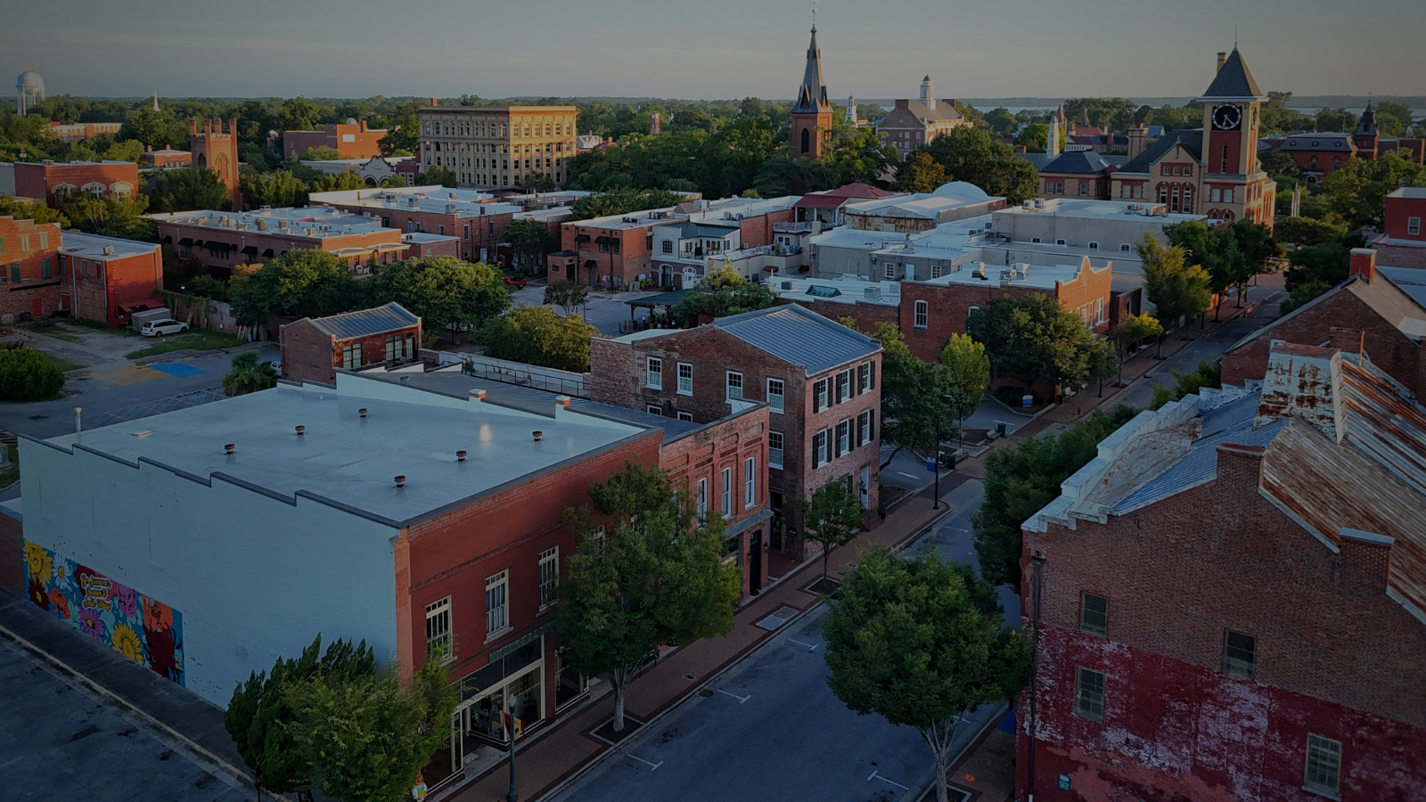 Charming view of downtown New Bern’s historic district, featuring red brick buildings, local shops, and a quiet summer morning.