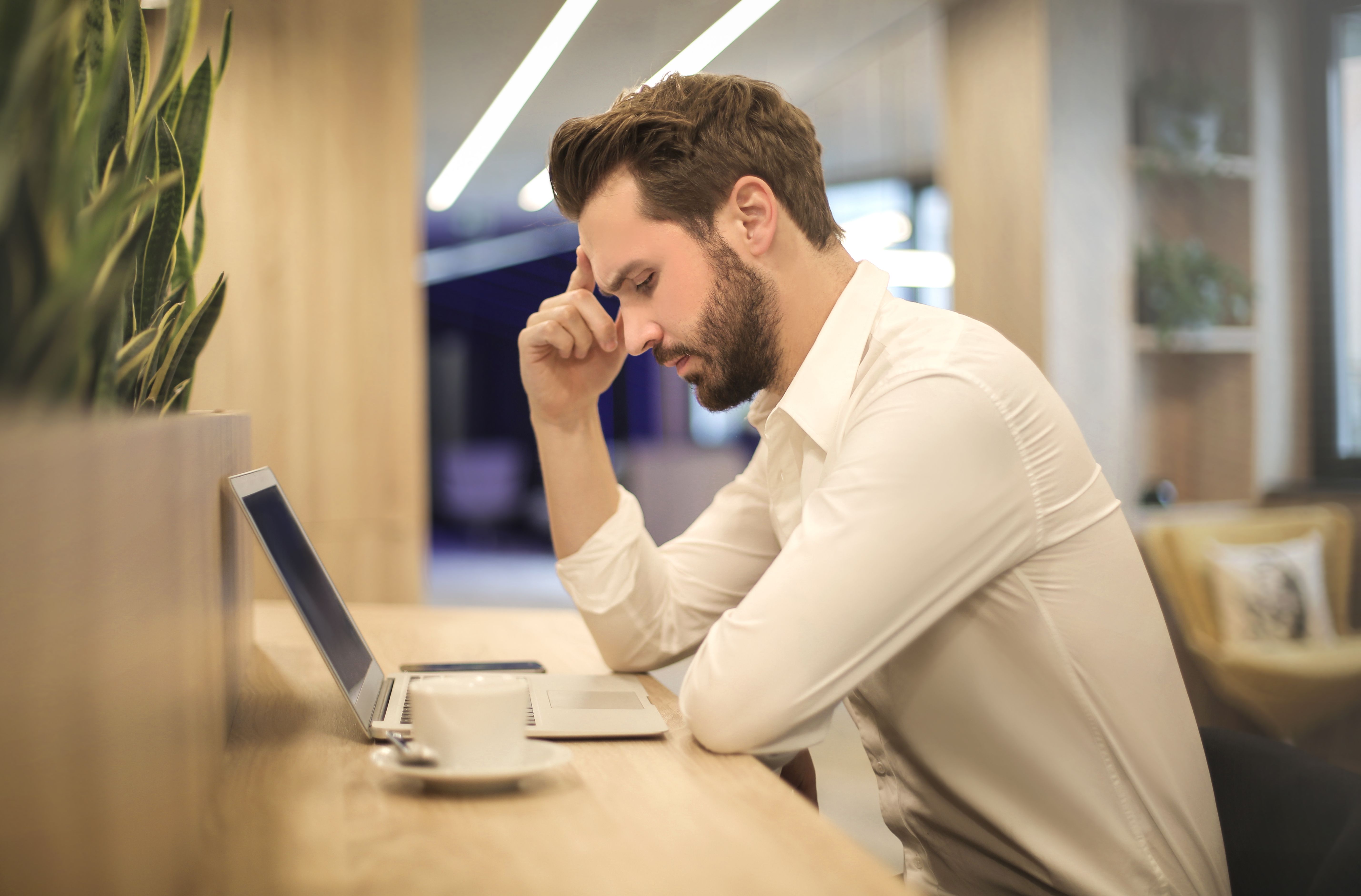 Home seller looking concerned while working on a laptop, symbolizing common pitfalls to avoid during the home-selling process.
