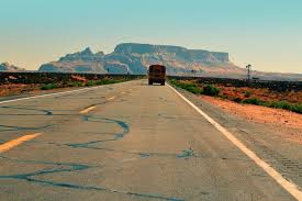 Scenic desert highway leading toward red rock mountains near St. George, Utah, representing relocating to Southern Utah and moving to a new community.