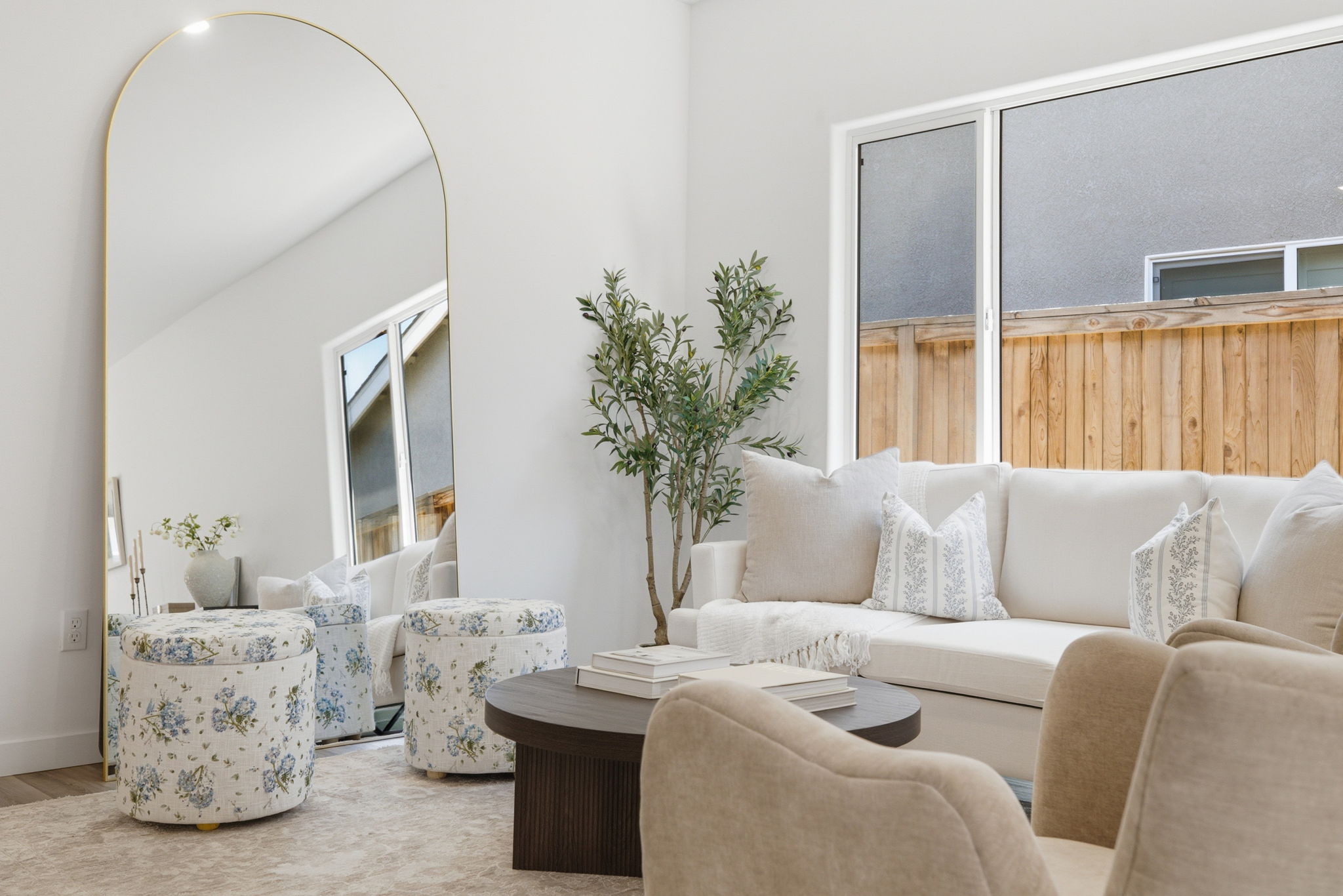 Bright staged living room in a Bakersfield home with large windows, neutral furnishings and modern interior design.