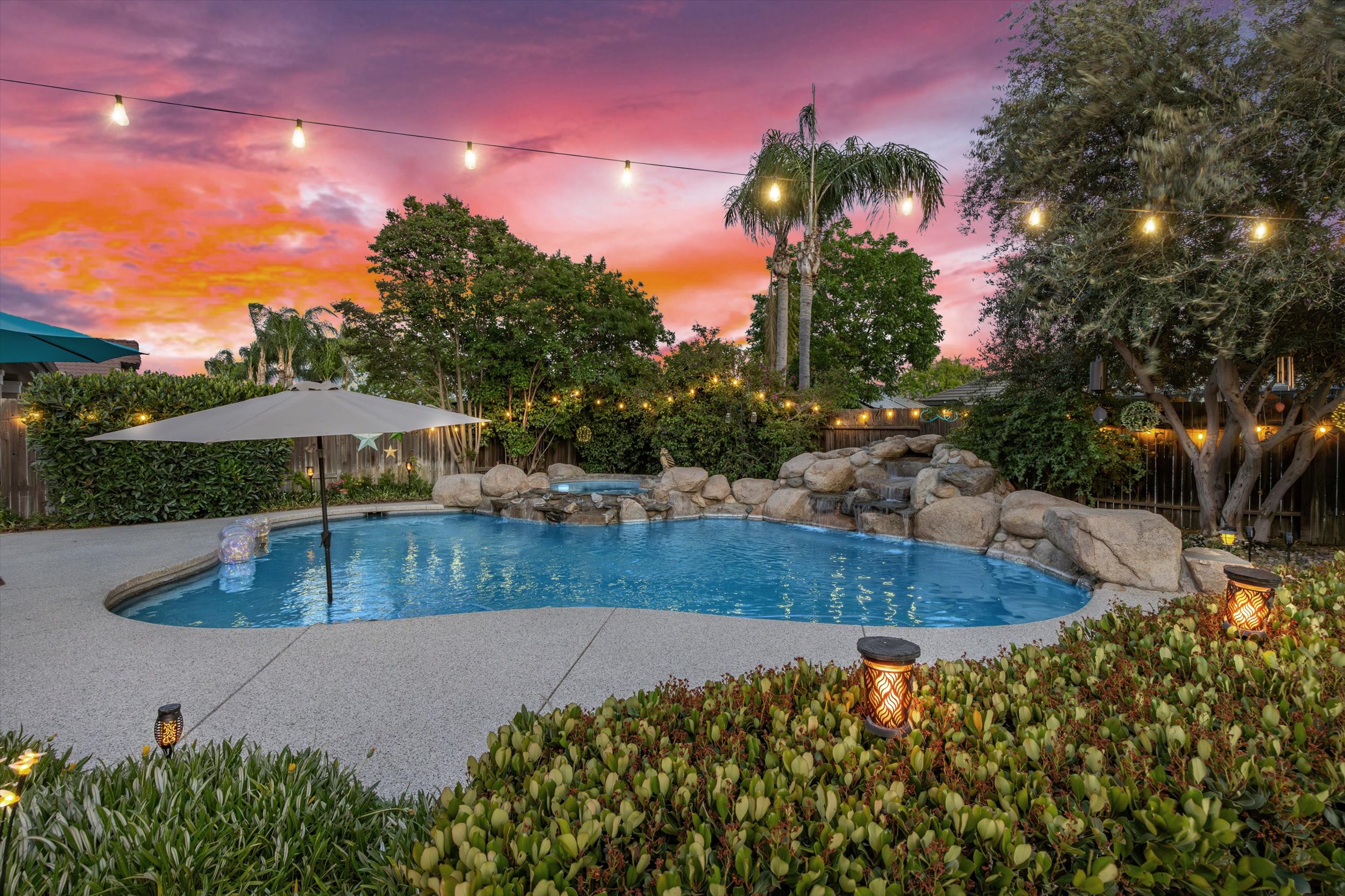 Bakersfield backyard pool with waterfall and string lights at 14005 Austin Creek Avenue