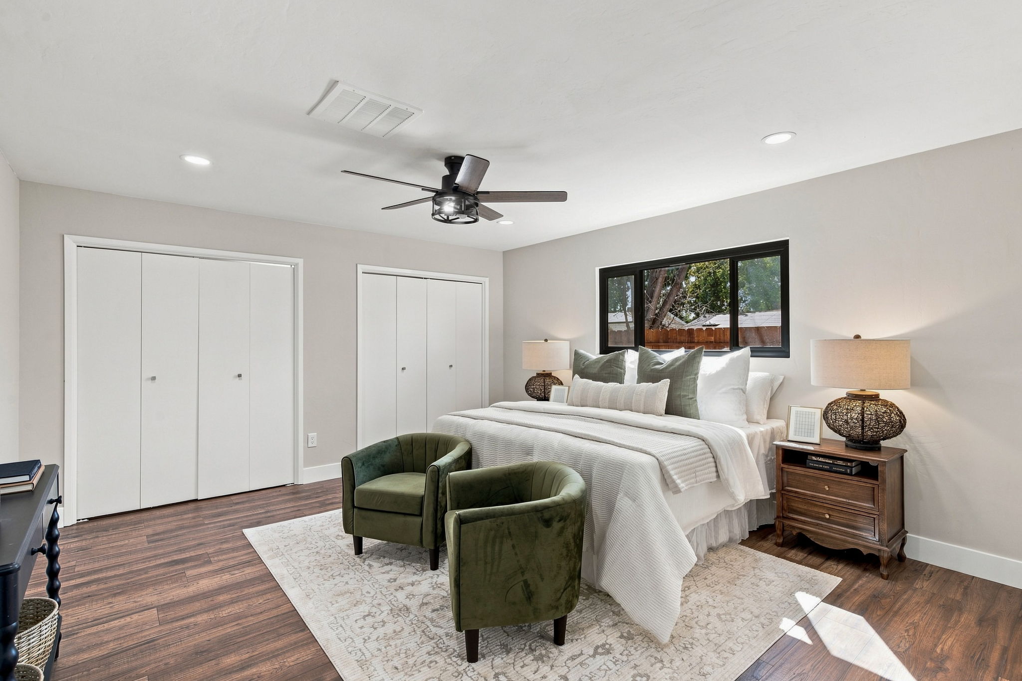 Staged primary bedroom in a Bakersfield home with wood-look flooring, modern lighting and neutral finishes prepared for sale.