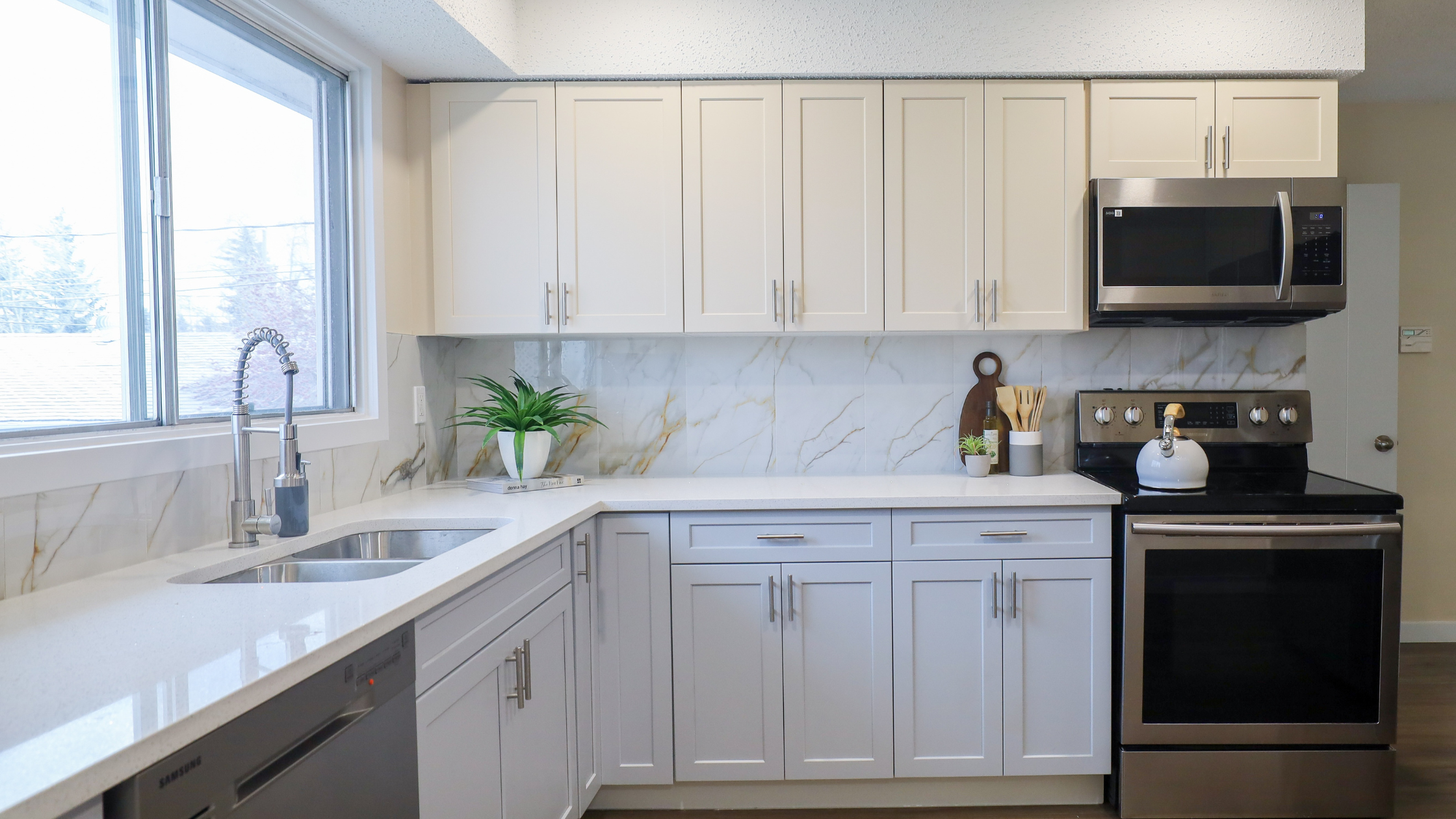 Updated kitchen in Bakersfield home featuring white cabinets, solid countertops, and stainless steel appliances