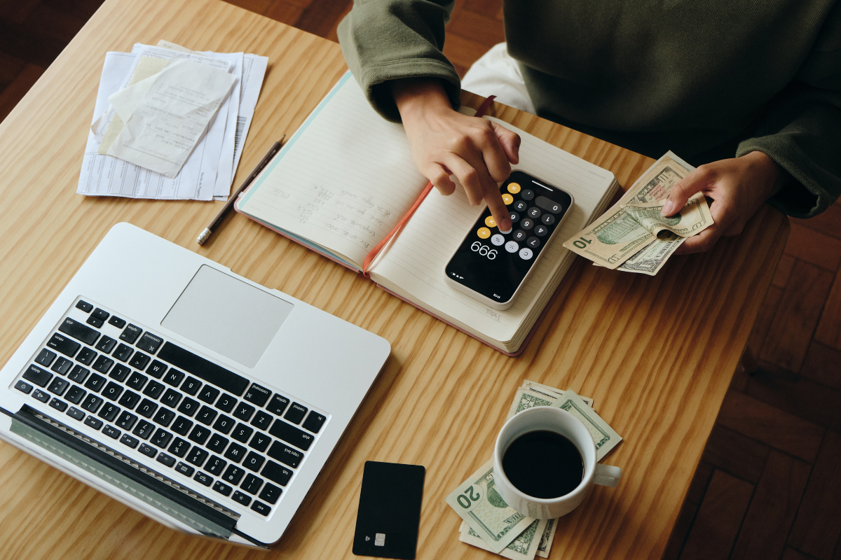 Person managing rent and budgeting with cash, receipts, and a calculator—illustrating how on-time rent payments can now help qualify for a mortgage.